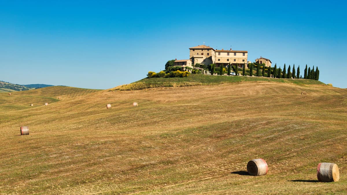 A building sits atop a hill in a scenic landscape.