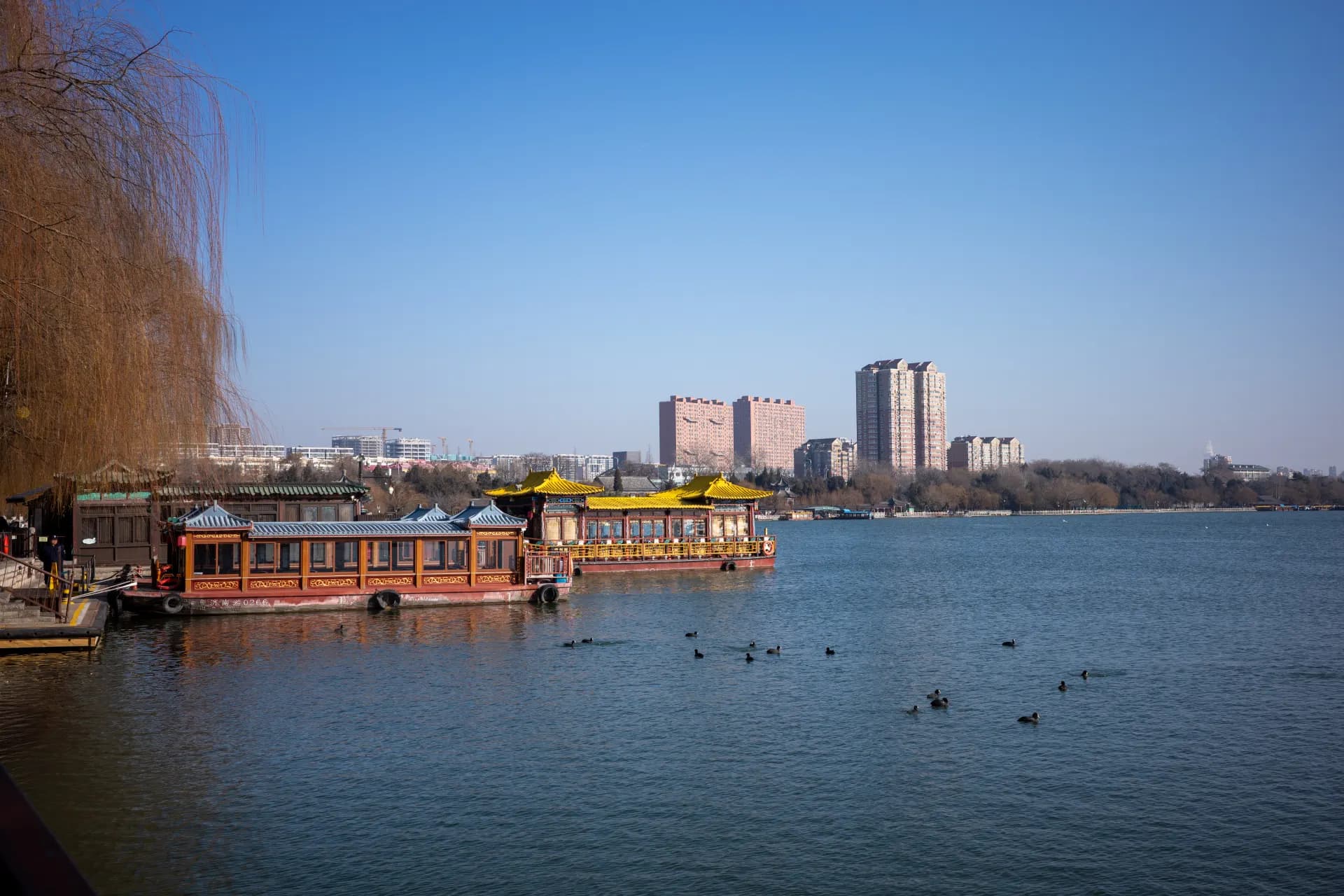 Boats on a lake with buildings in the background