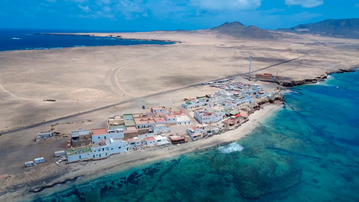A coastal town sits on a sandy strip.