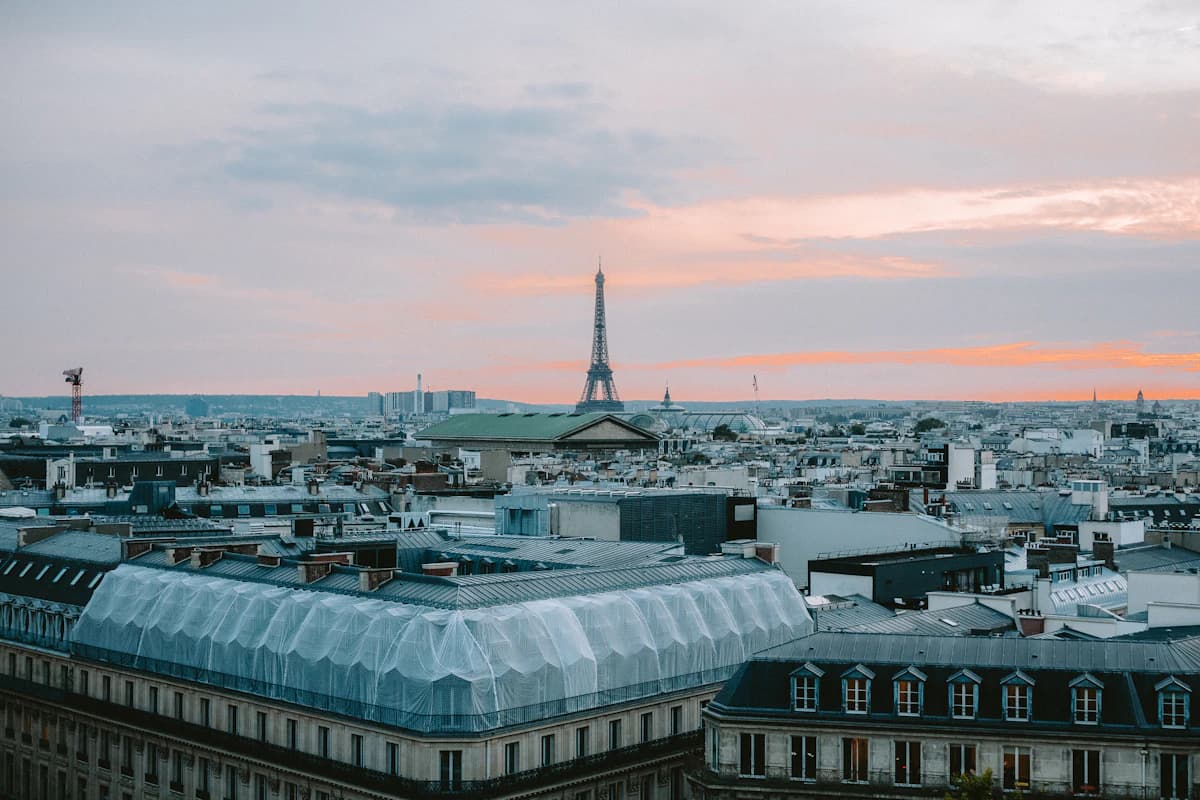 Eiffel tower visible over paris rooftops at dusk