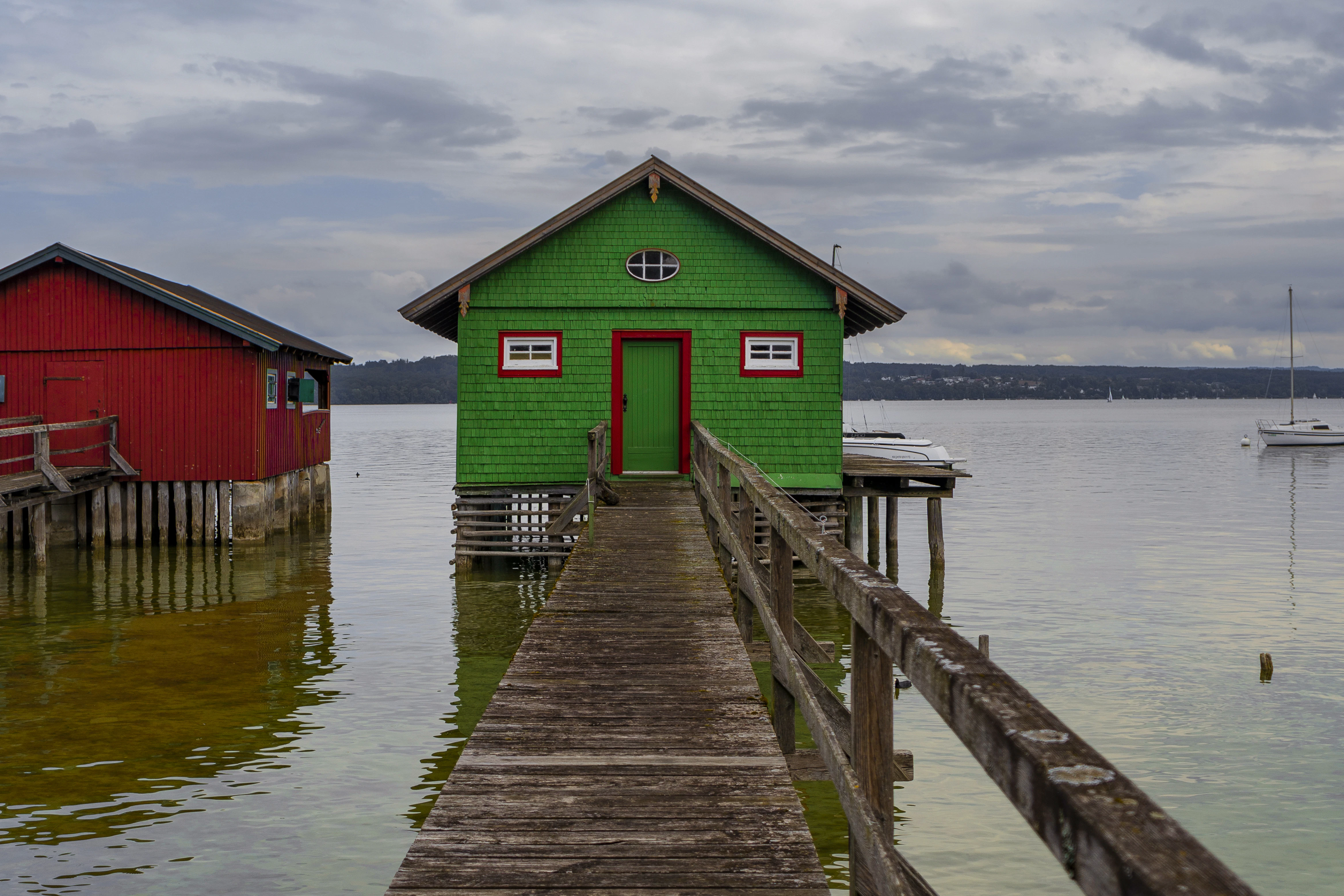 A dock with two red and green houses on it