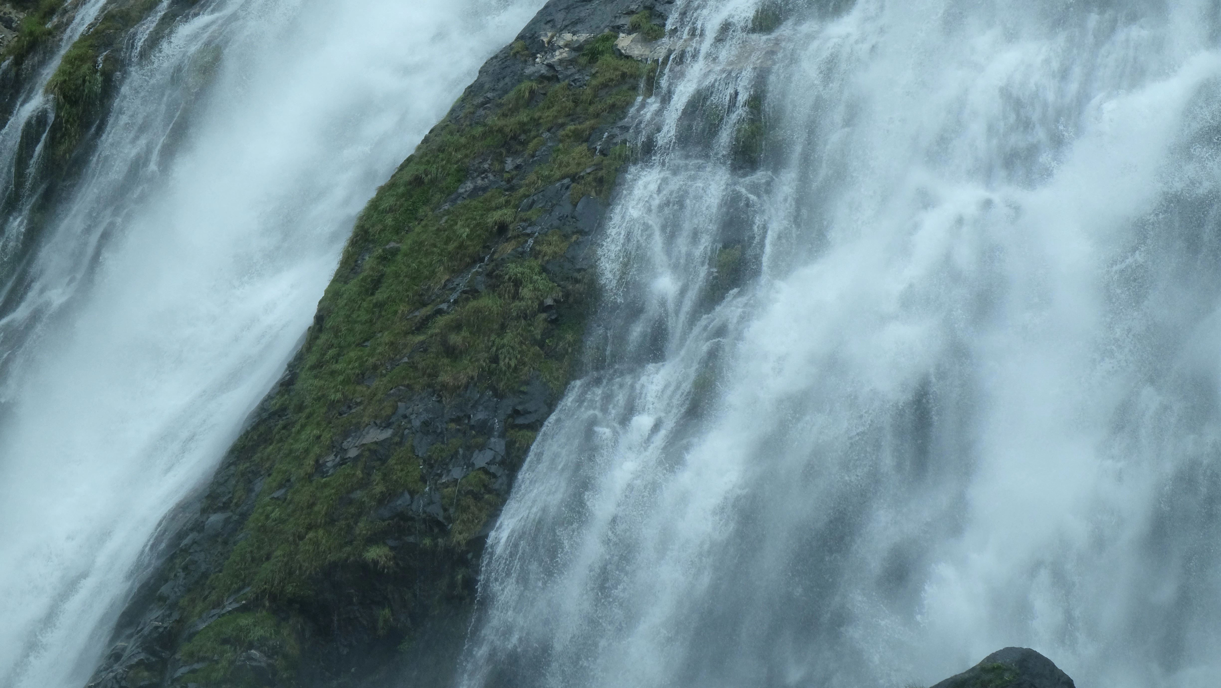 a man standing in front of a waterfall
