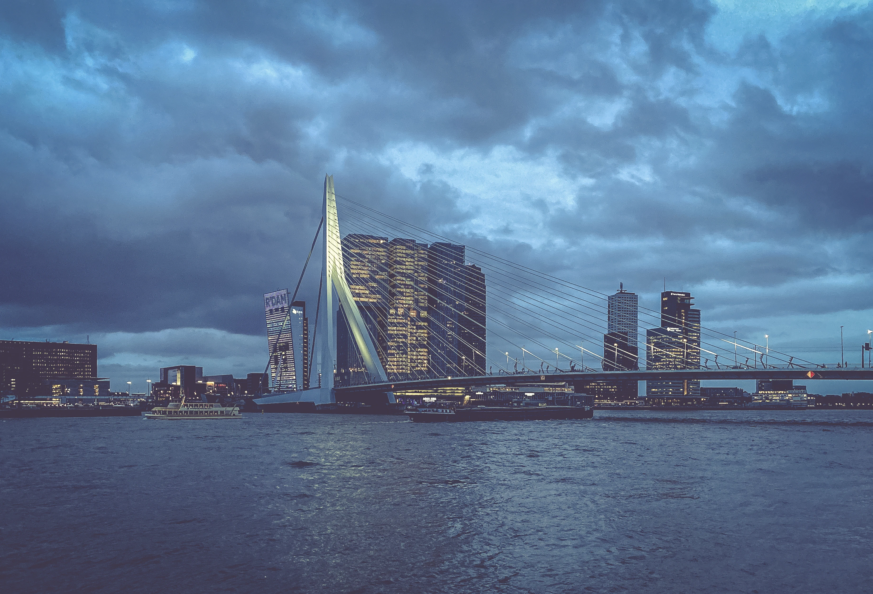 city skyline across body of water under cloudy sky during daytime