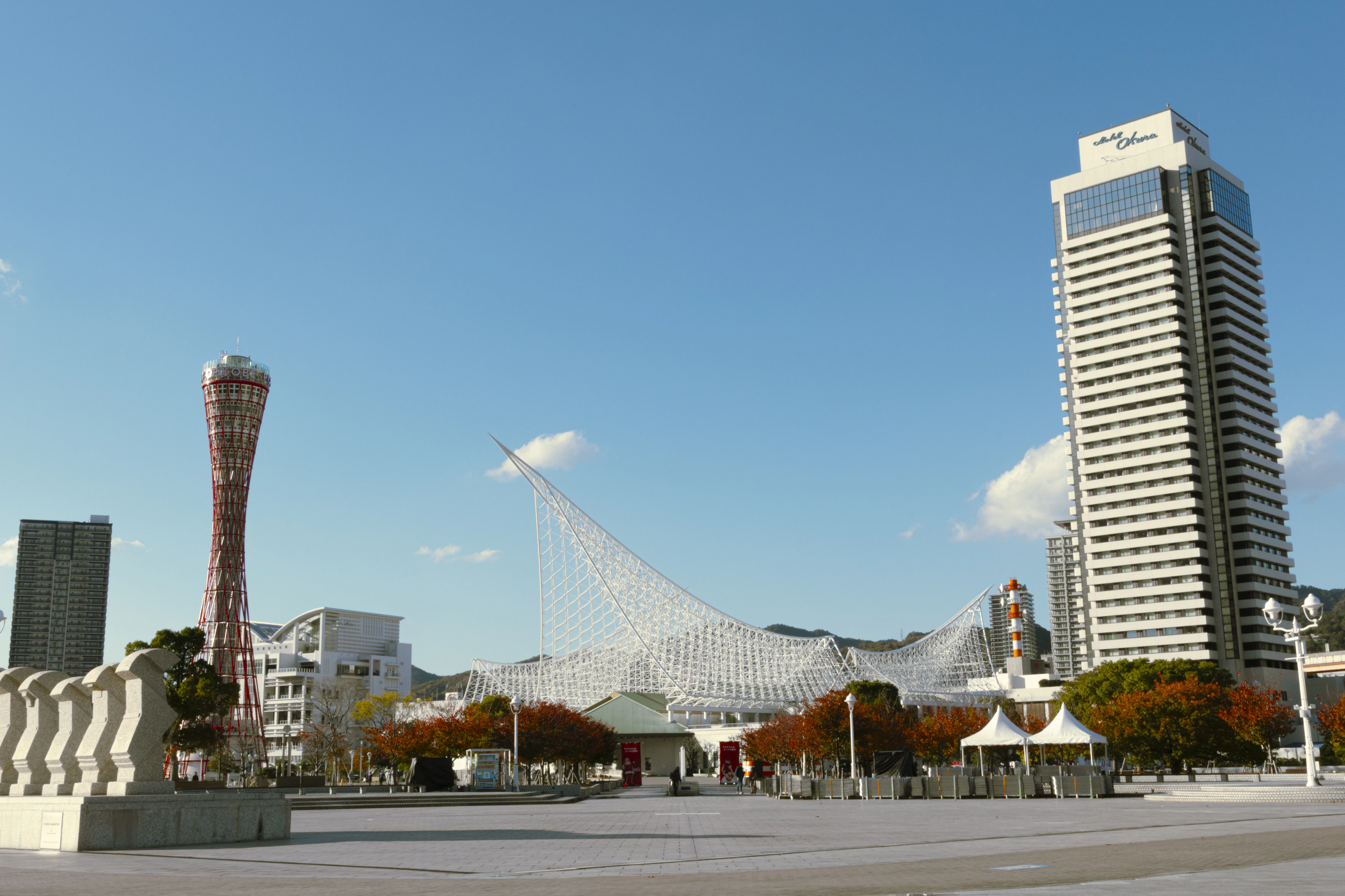 Modern buildings stand against a bright blue sky.