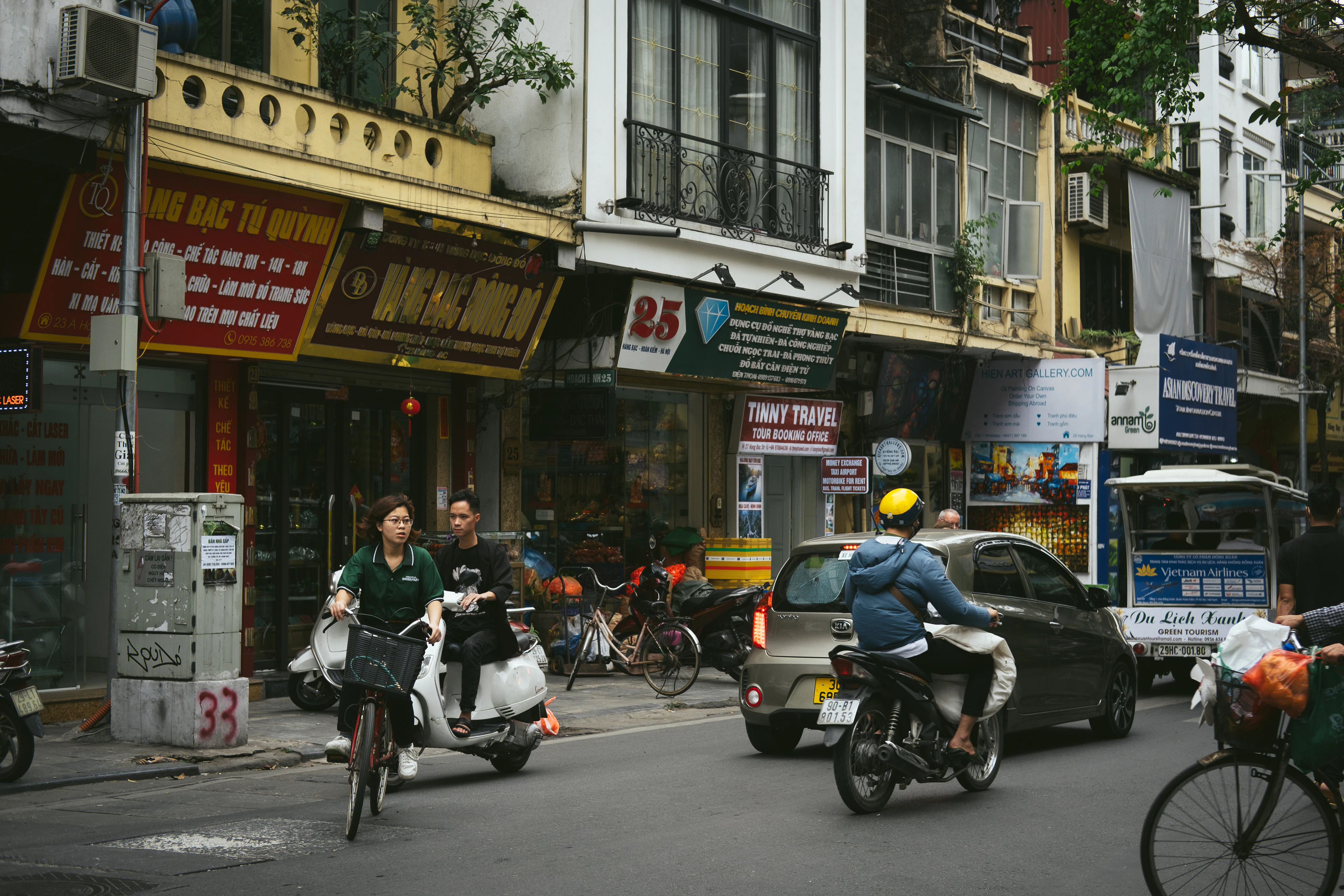 A group of people riding bikes down a street