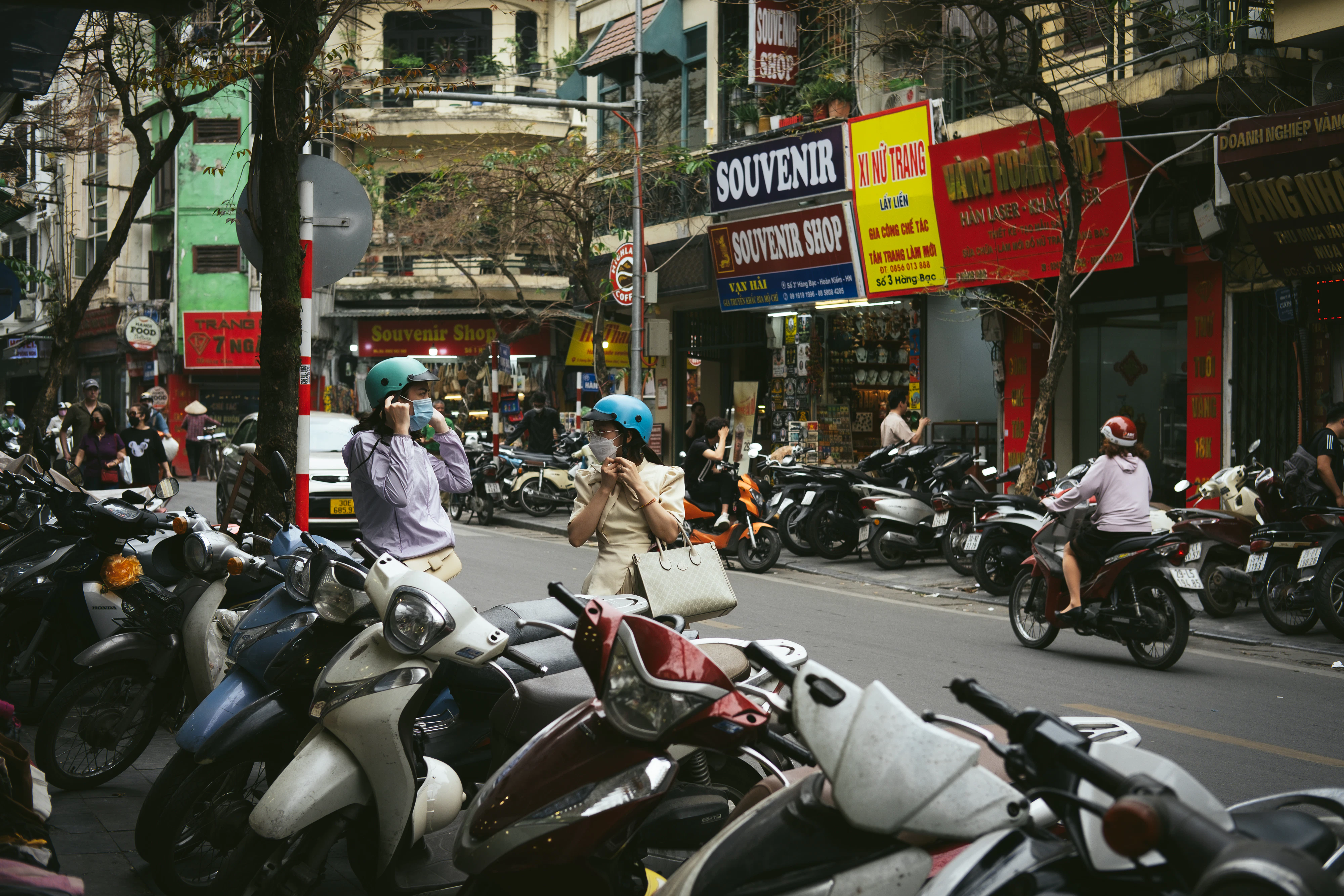 A group of people riding motorcycles down a street