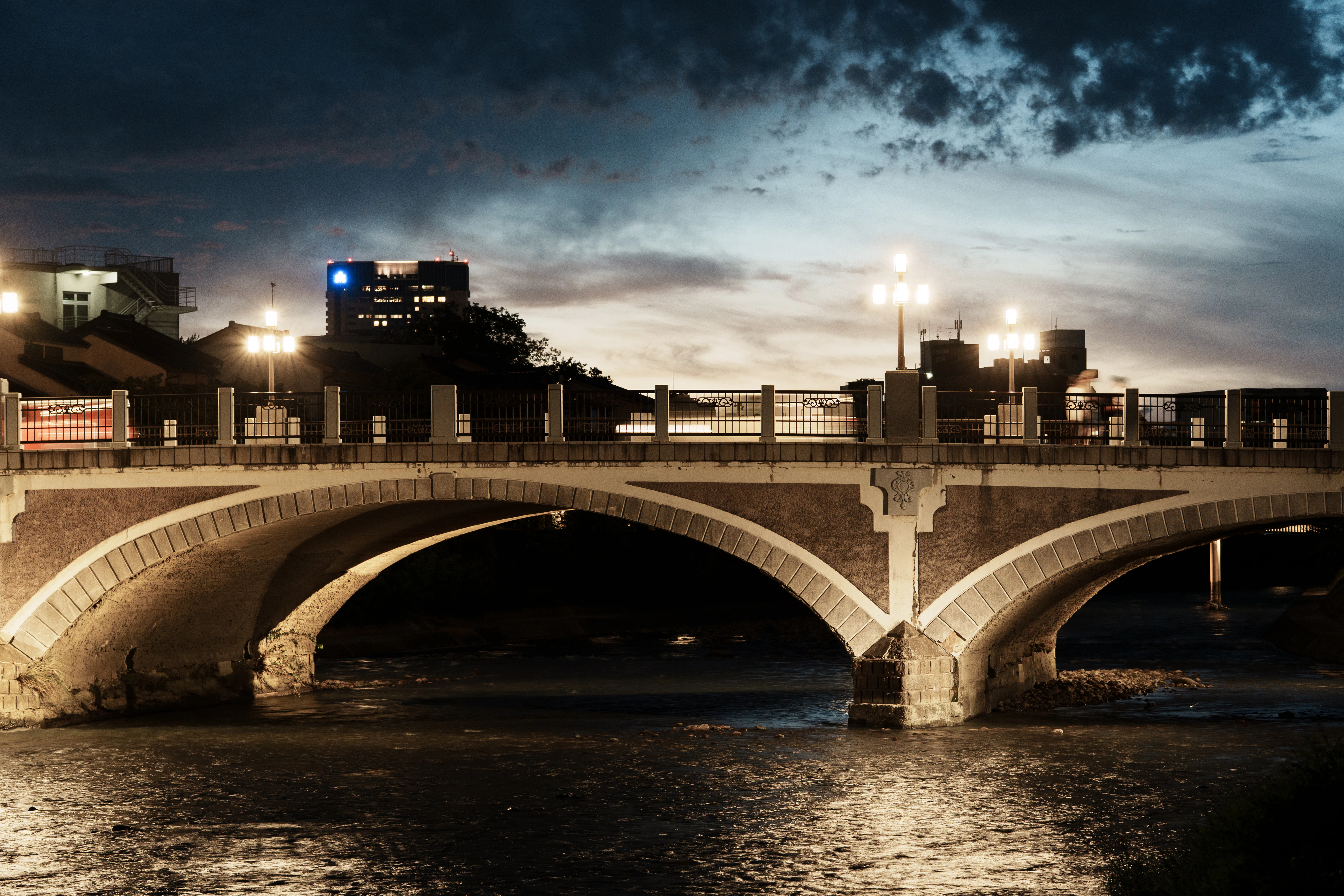 Illuminated bridge over water at night
