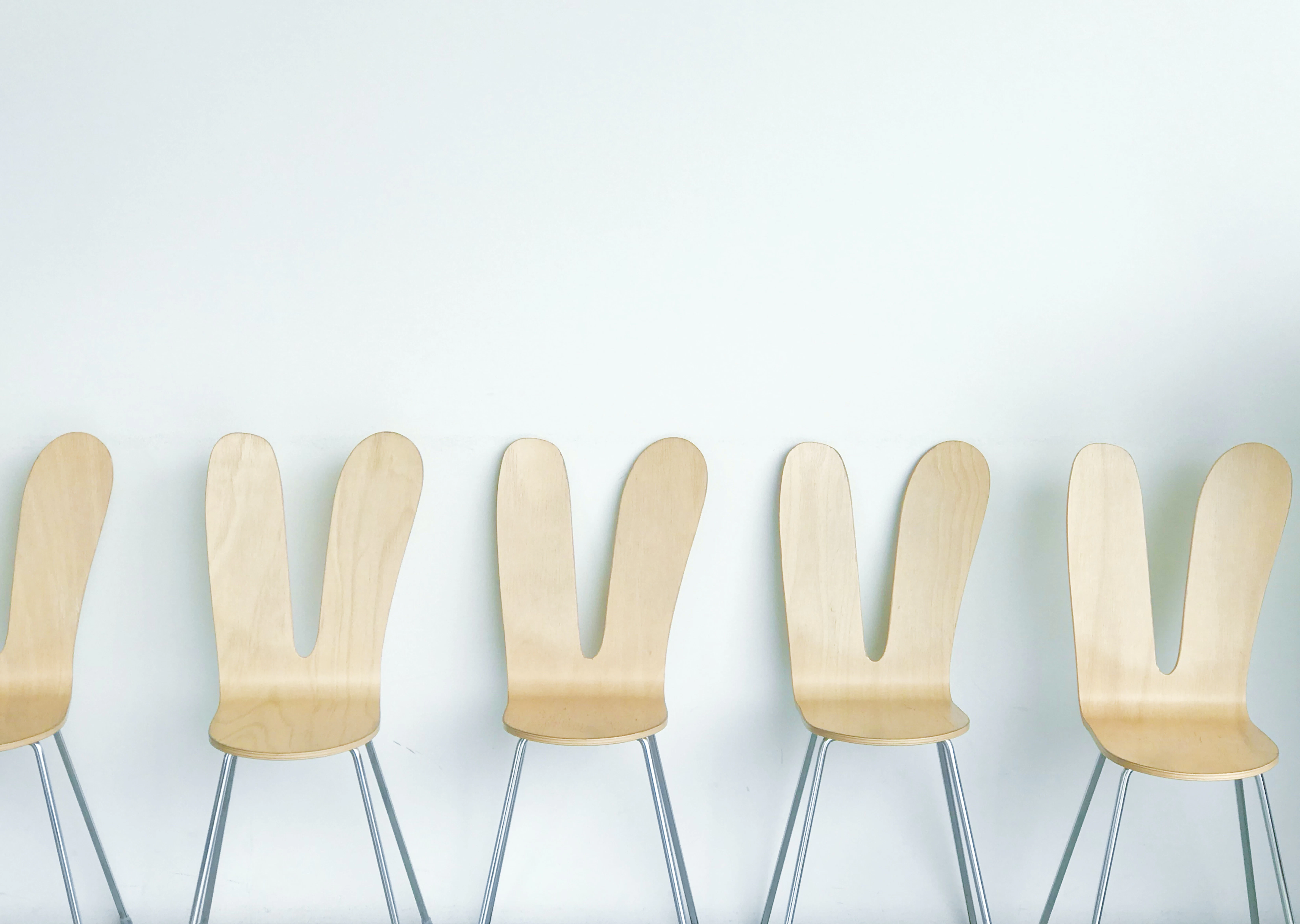 a row of wooden chairs sitting next to each other