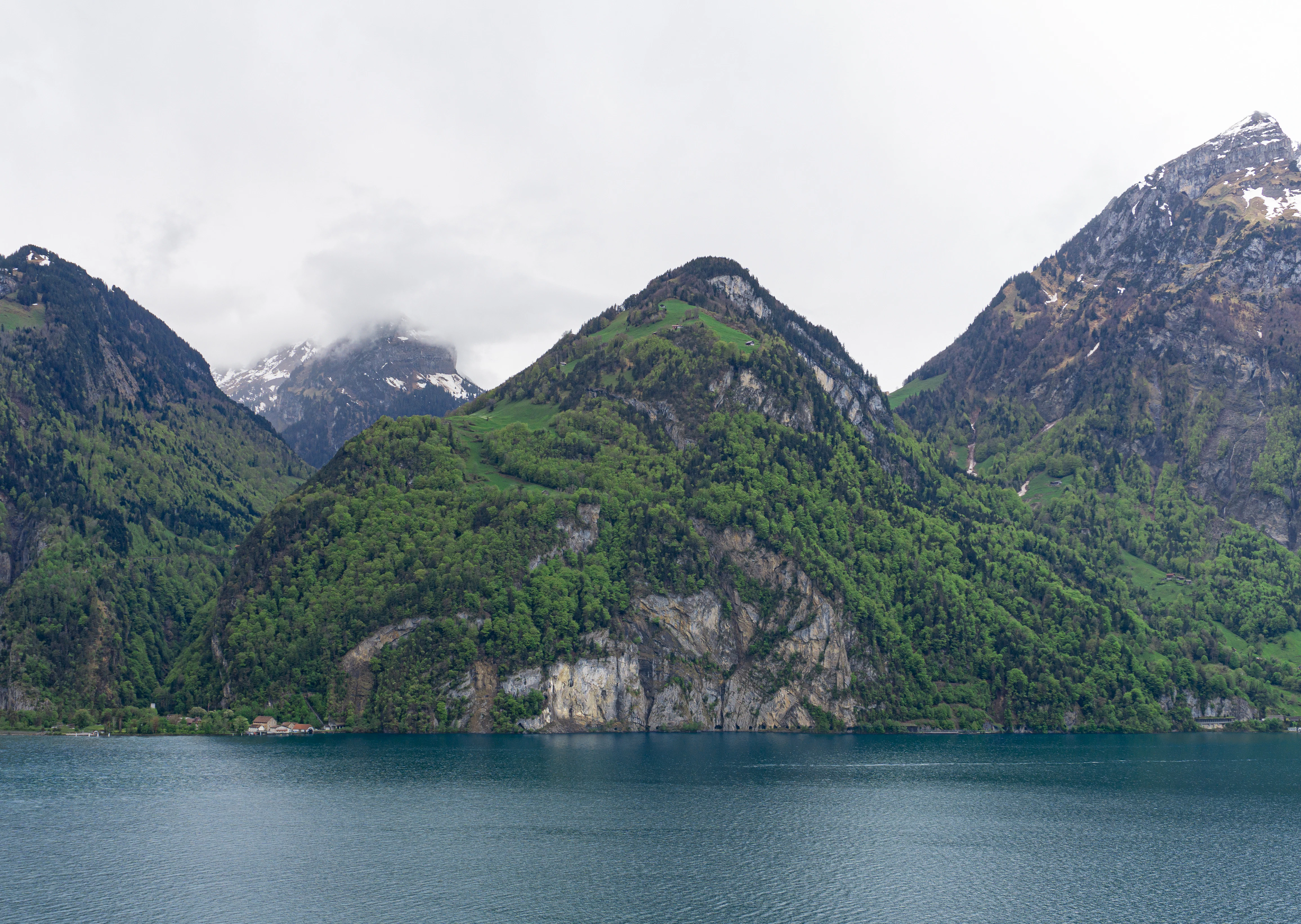 green mountain beside body of water during daytime