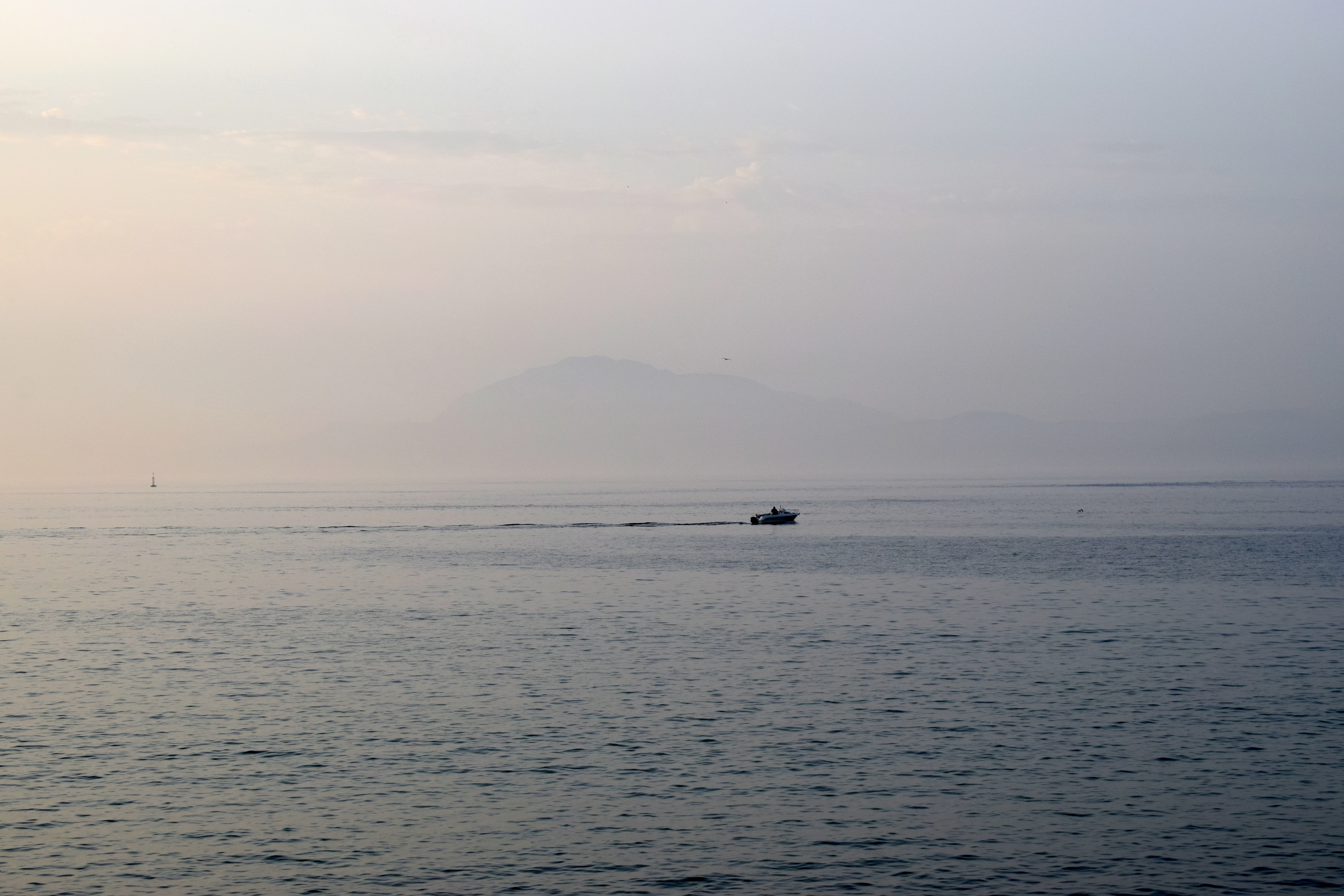 boat on sea under white sky during daytime