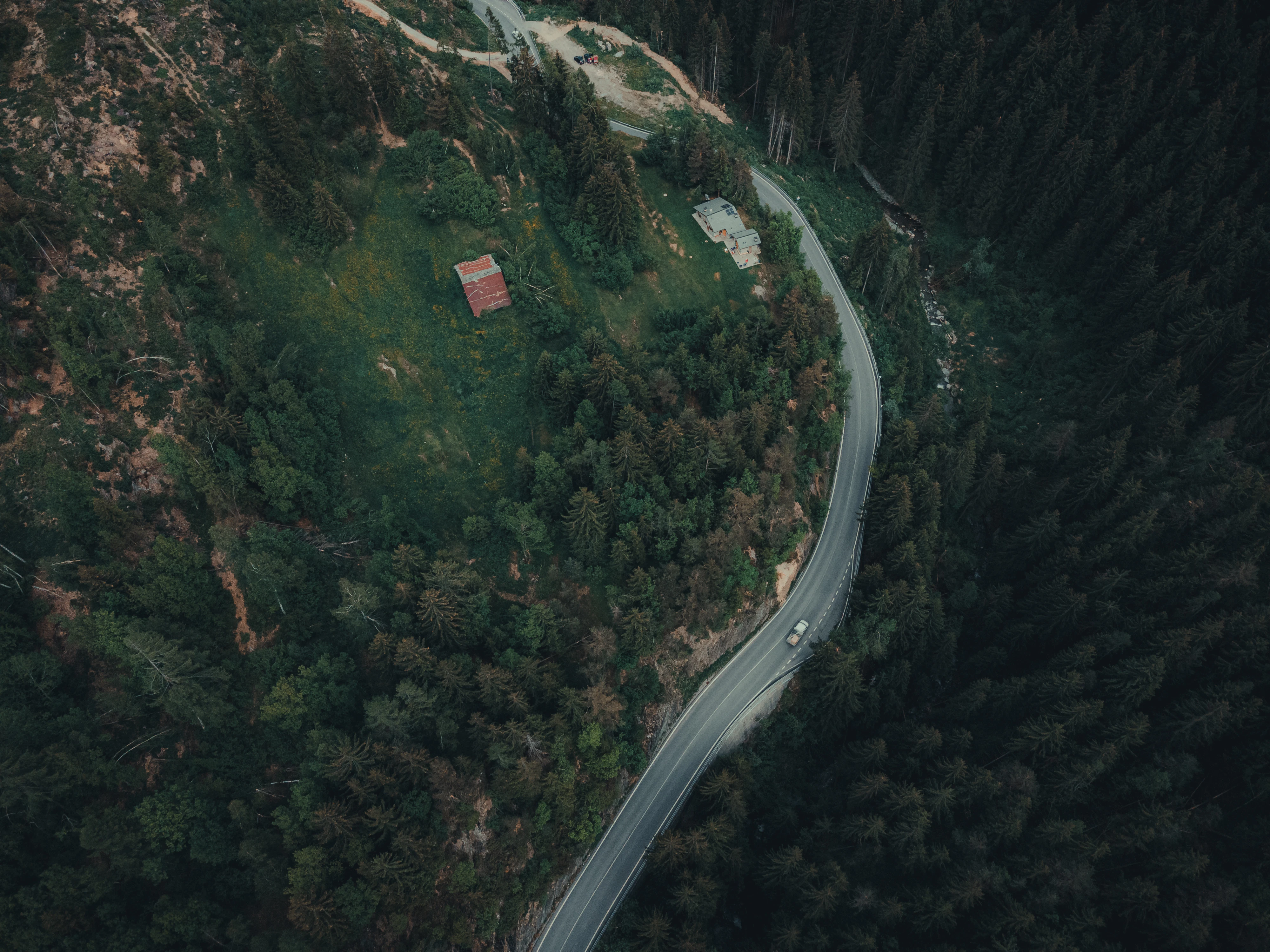 an aerial view of a road in the middle of a forest