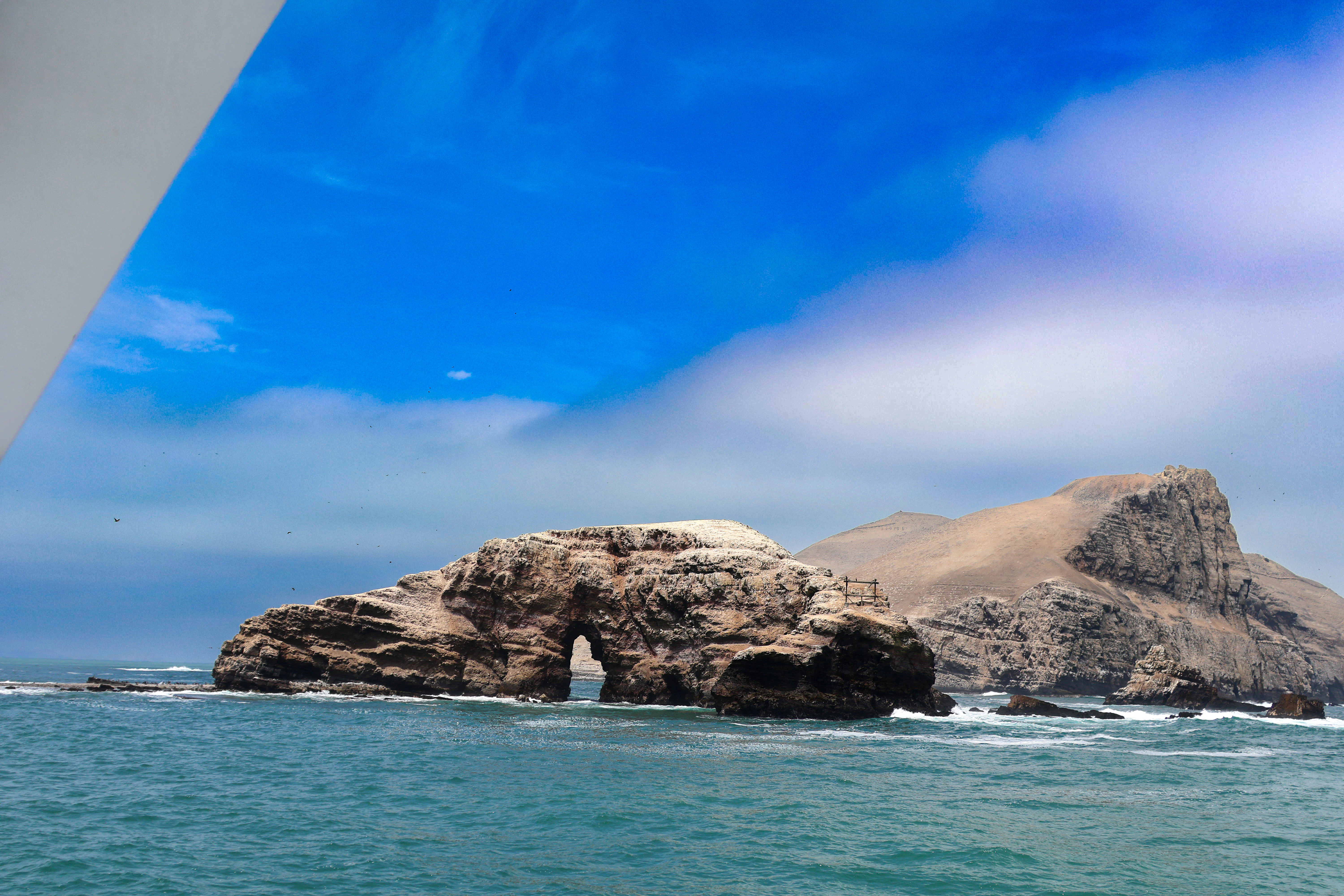A large rock in the middle of a body of water
