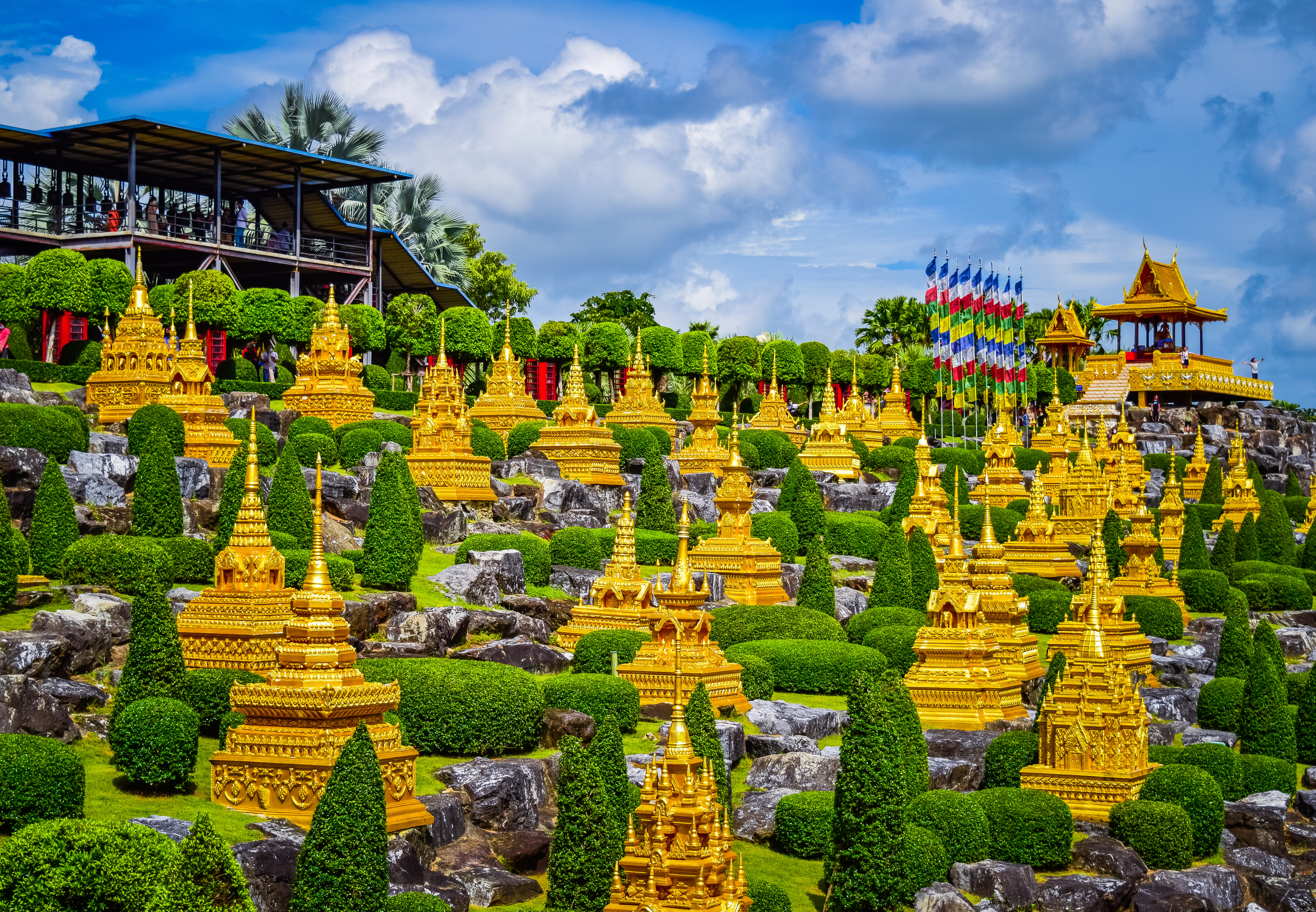 a large group of yellow statues in a garden
