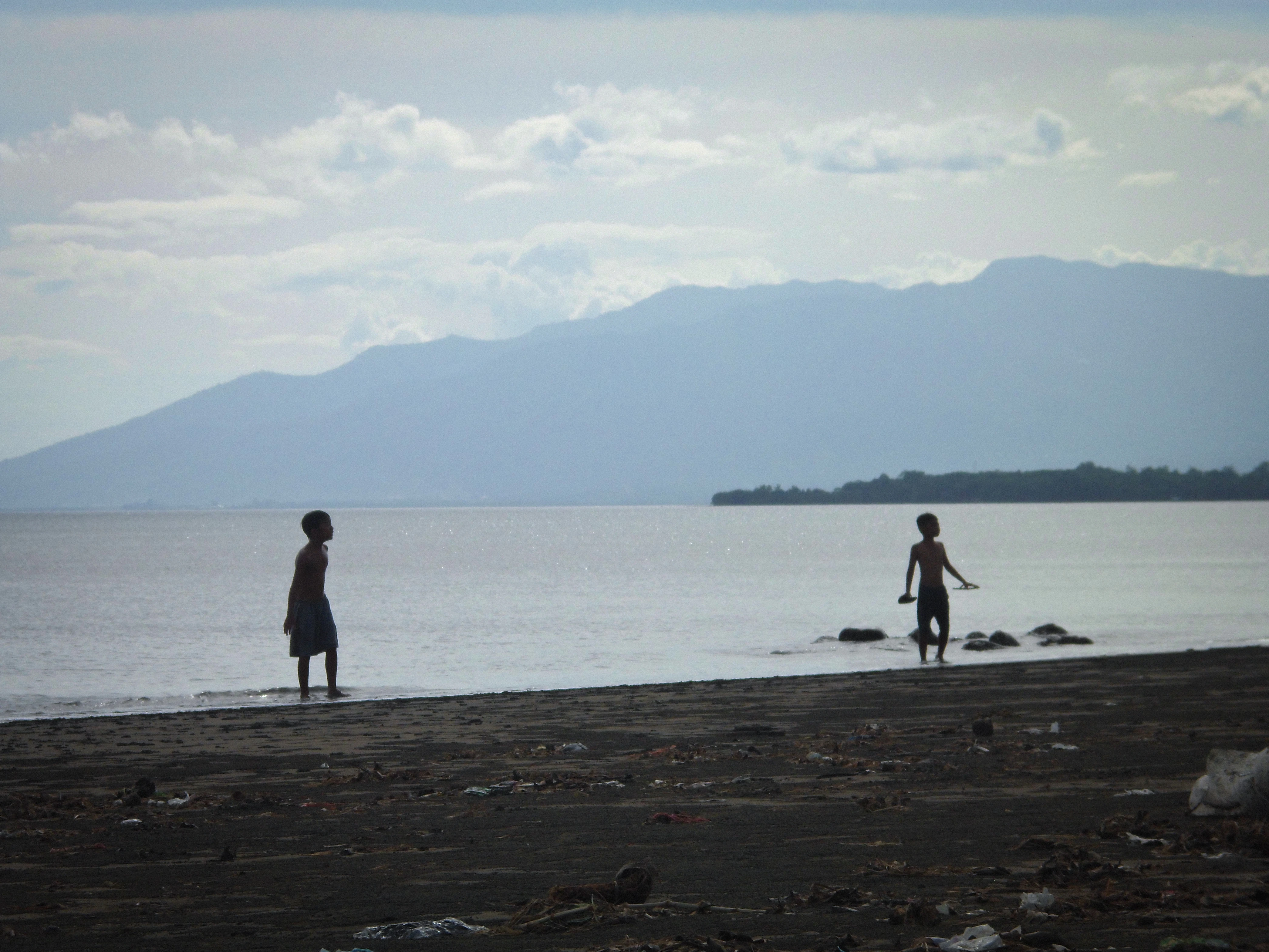 a couple of people standing on top of a beach