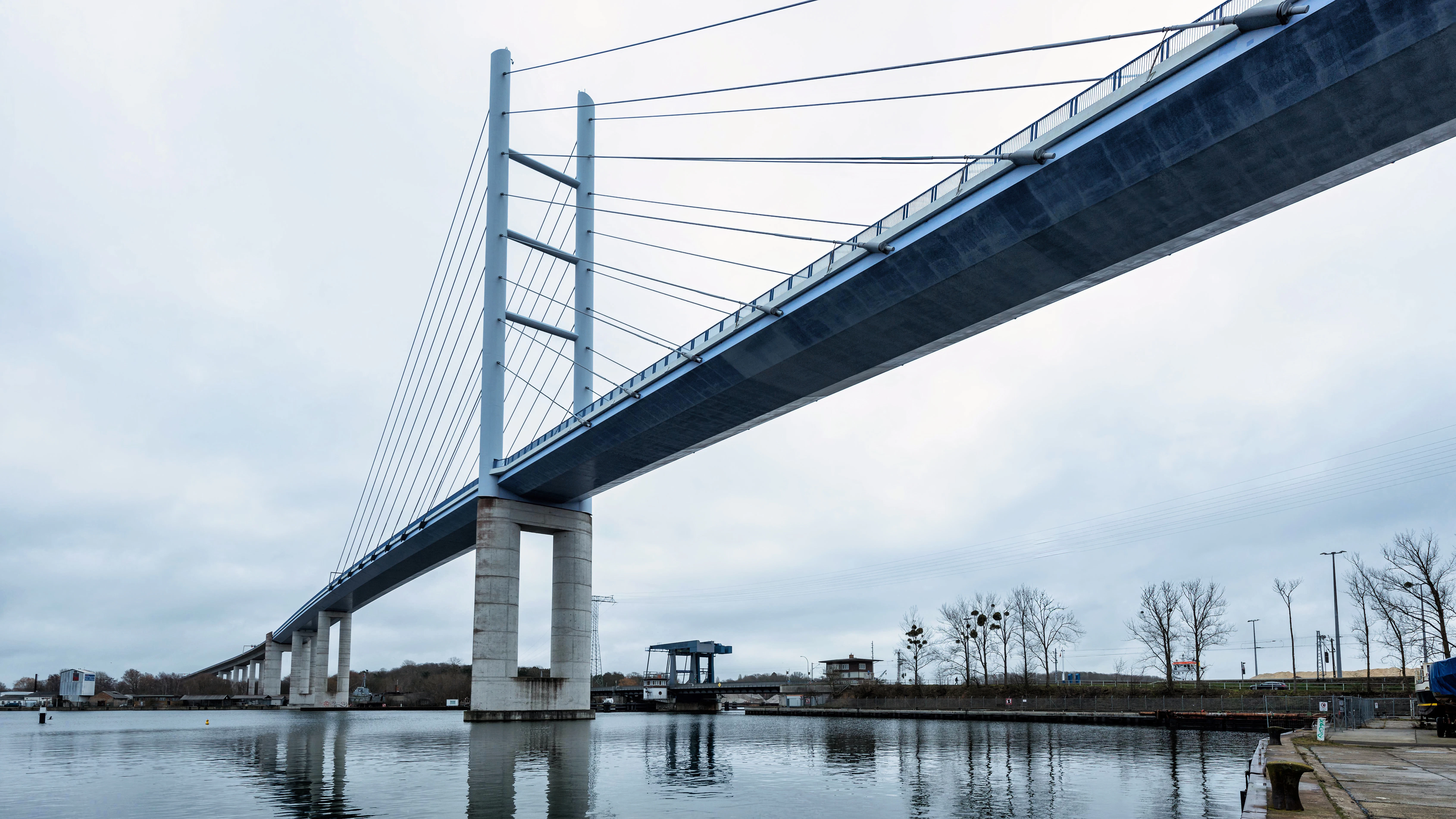 A modern cable-stayed bridge over calm water.