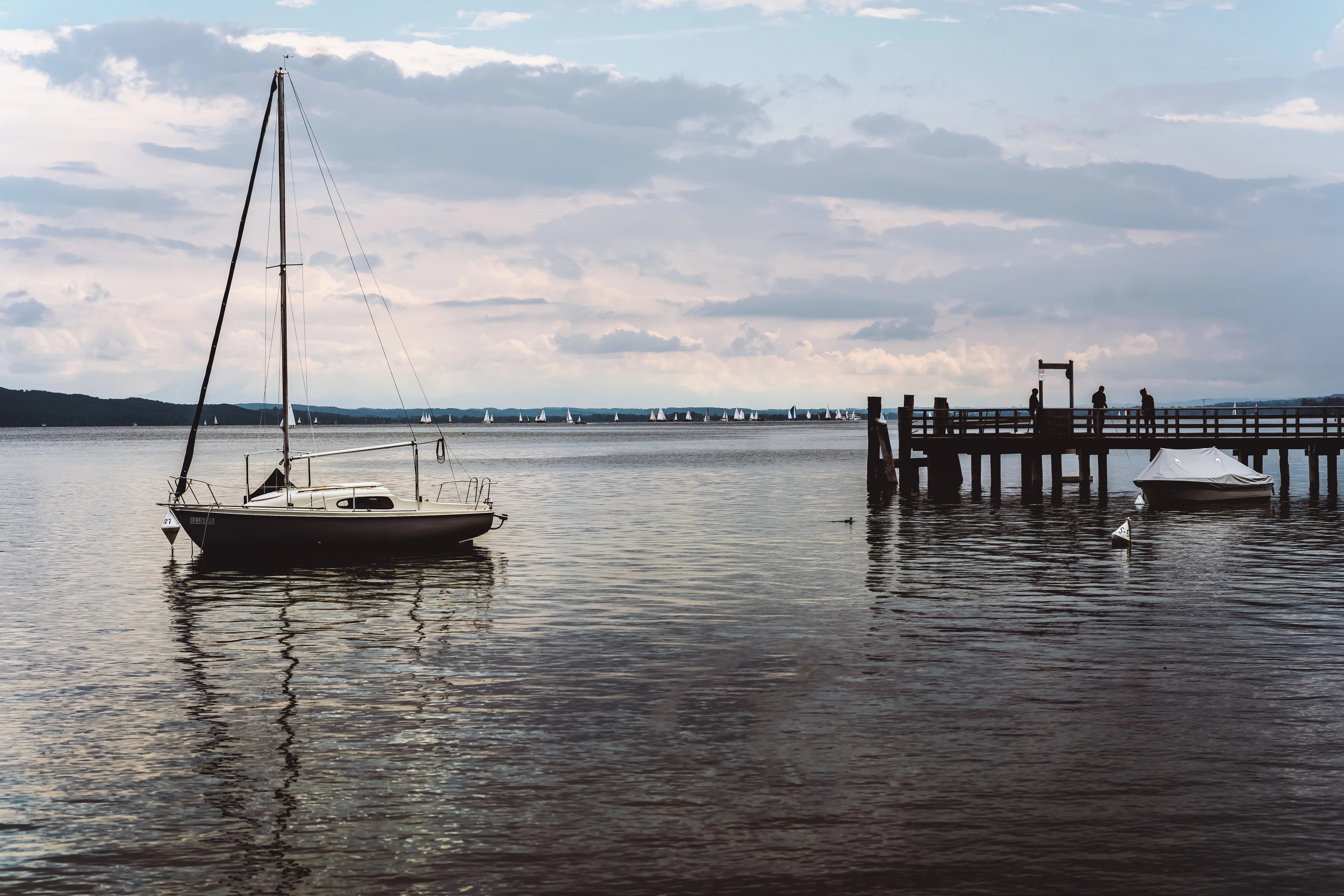 A sailboat is docked at a pier on a lake