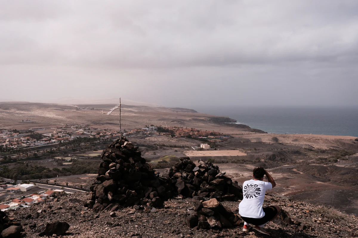 a man sitting on a rock overlooking a city