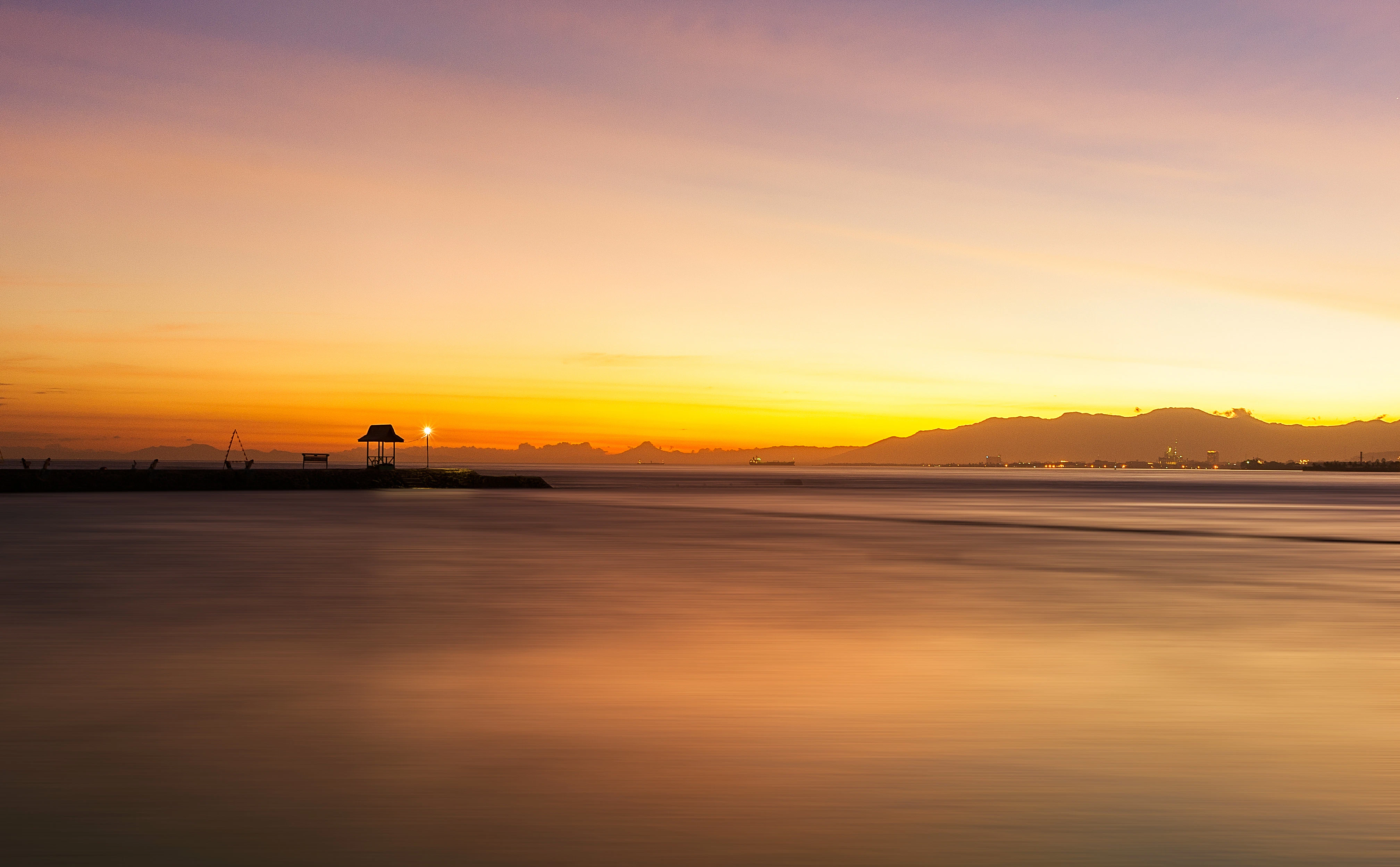 silhouette of boat on sea during sunset