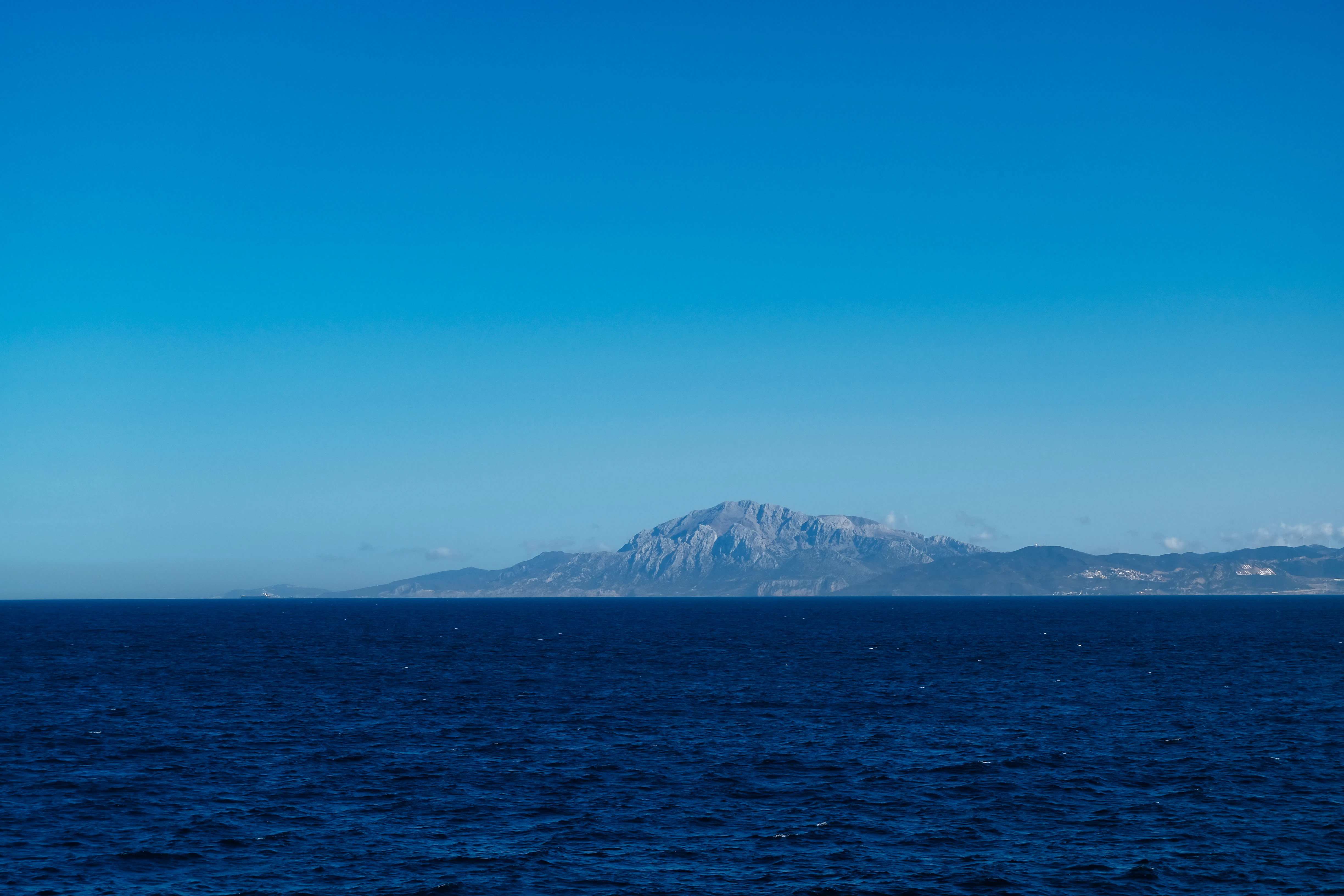 Distant mountain range across the deep blue sea.