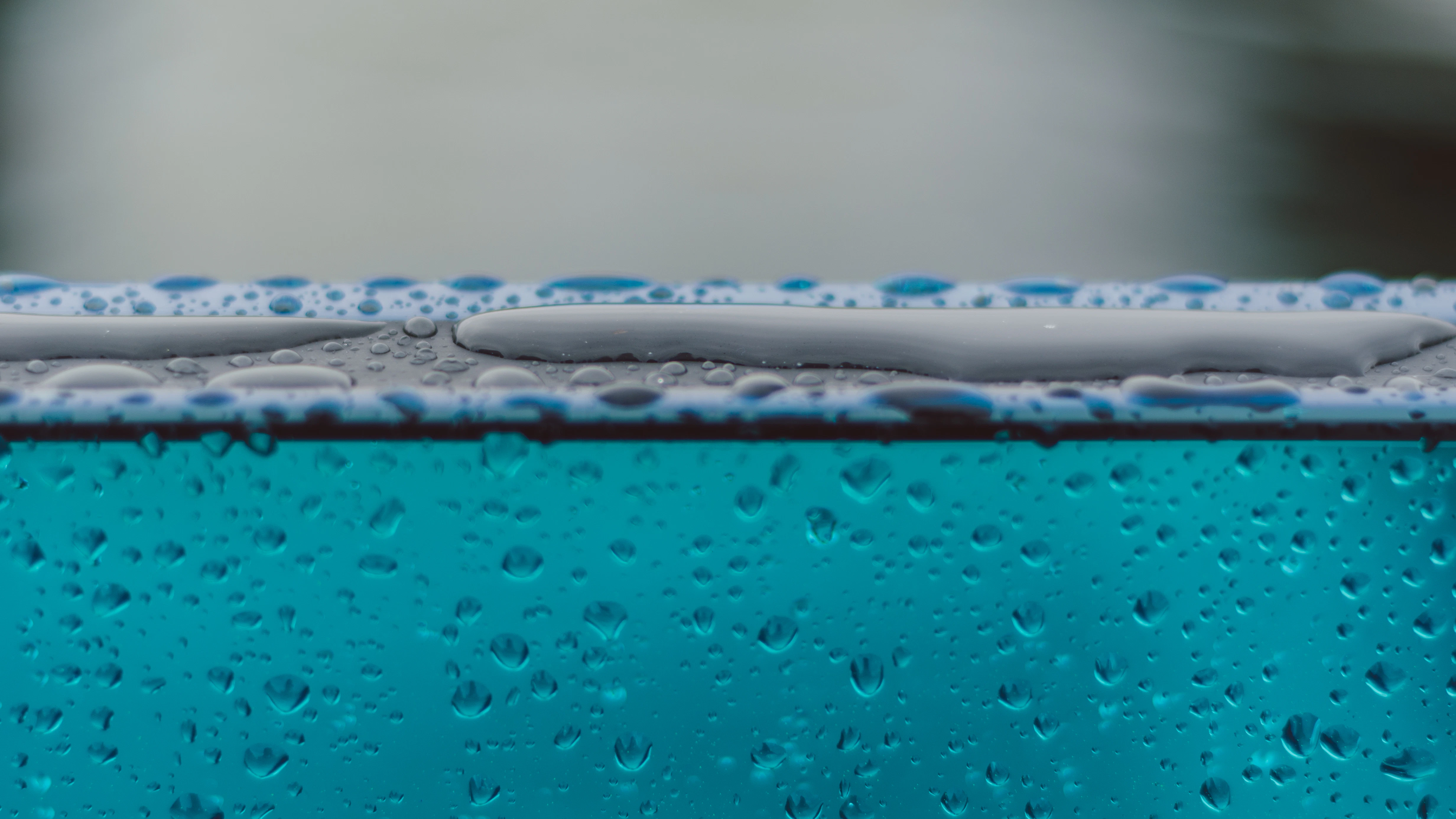macro photography of water drops on glass surface