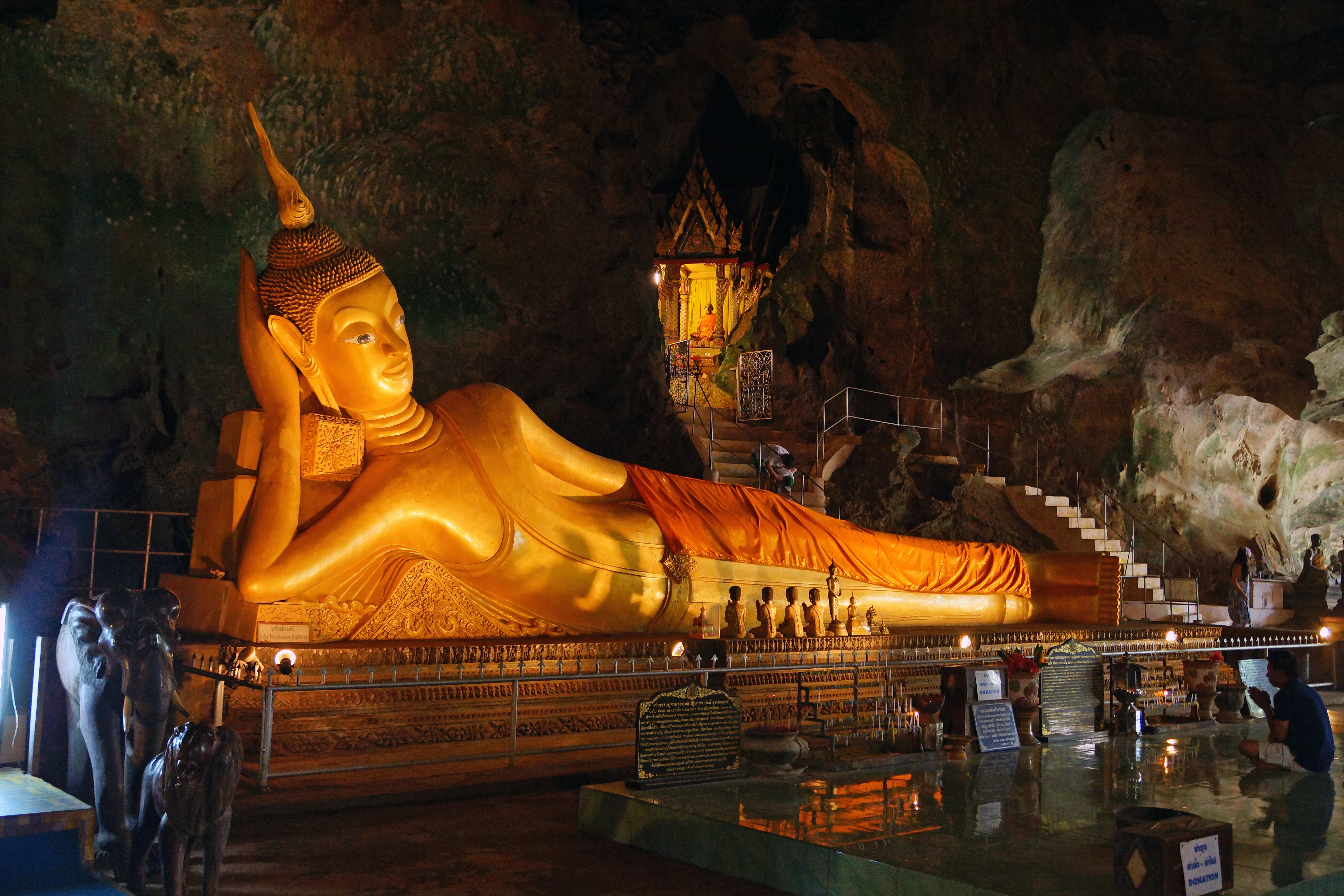 A large buddha statue sitting in the middle of a cave