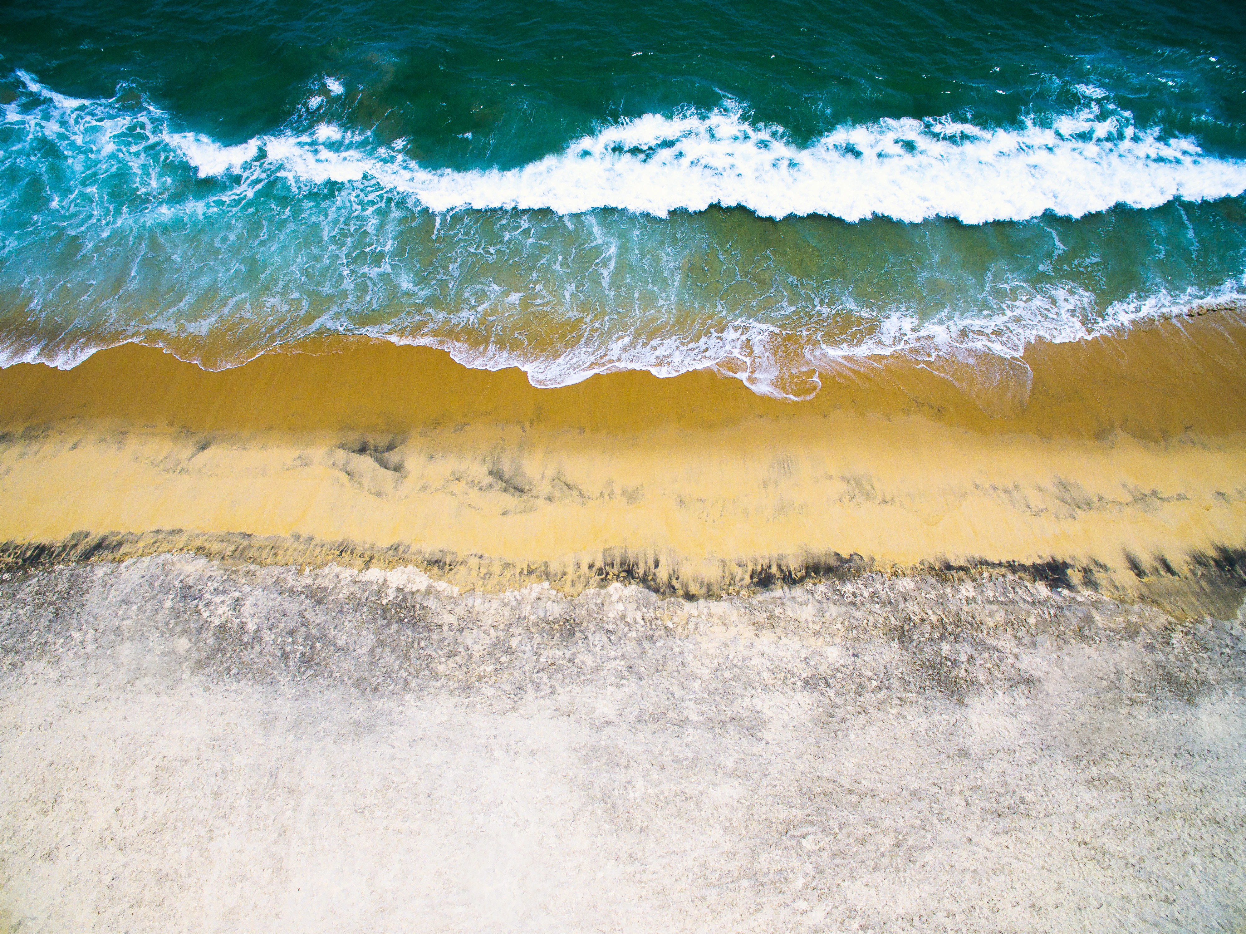 sea waves crashing on shore during daytime