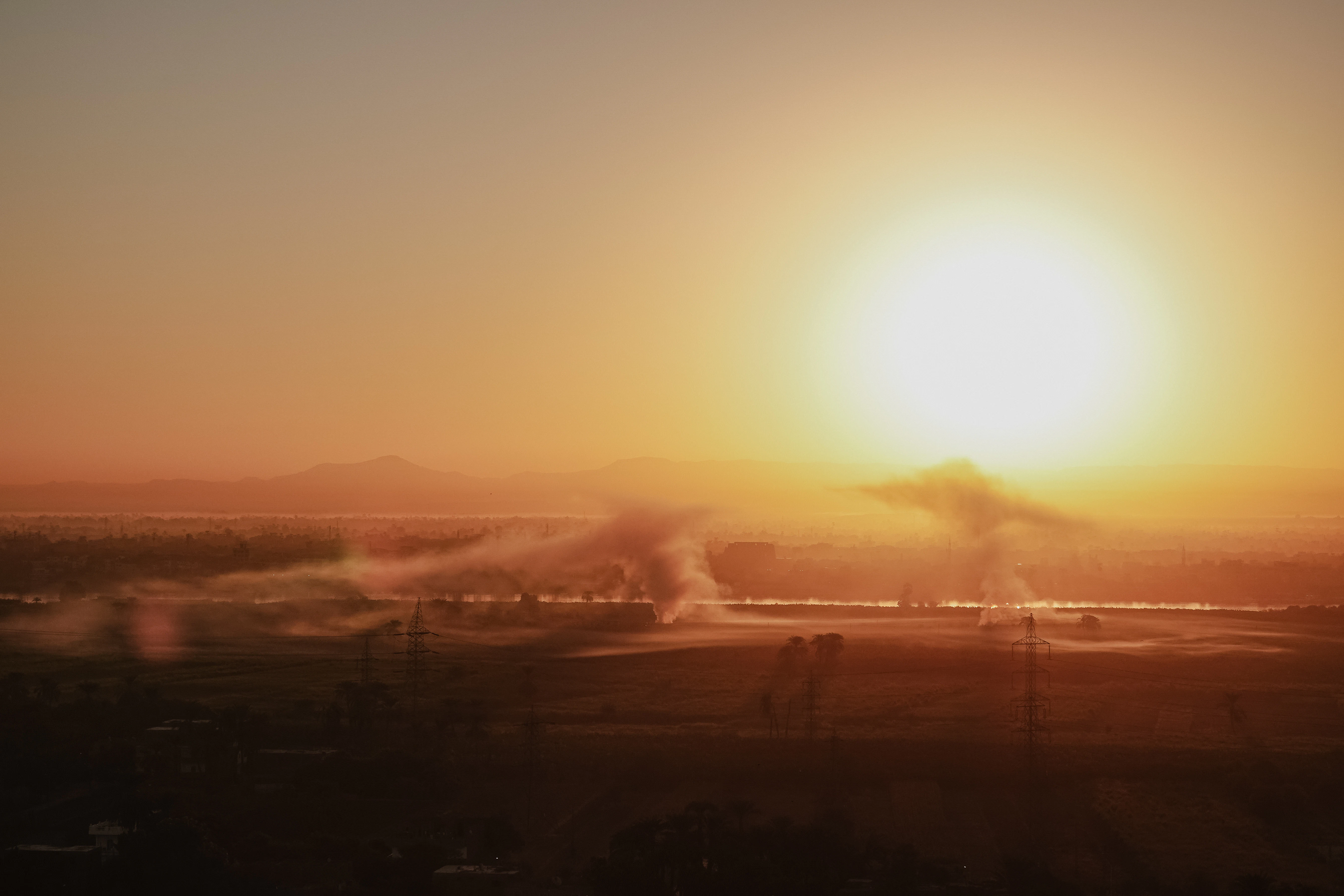 Bright sun setting over irrigated farmland at sunset.