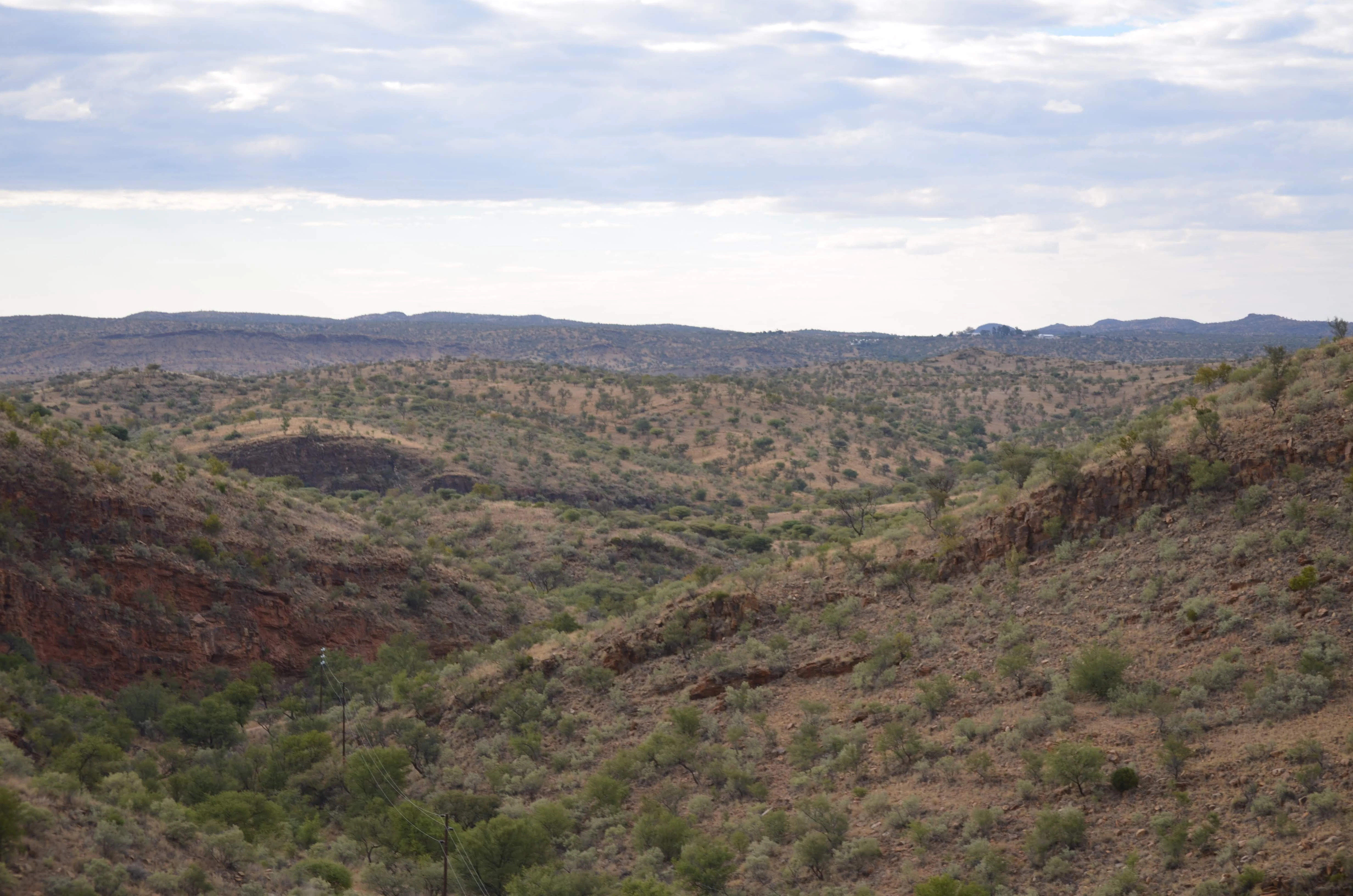 Arid landscape with rolling hills and sparse vegetation.