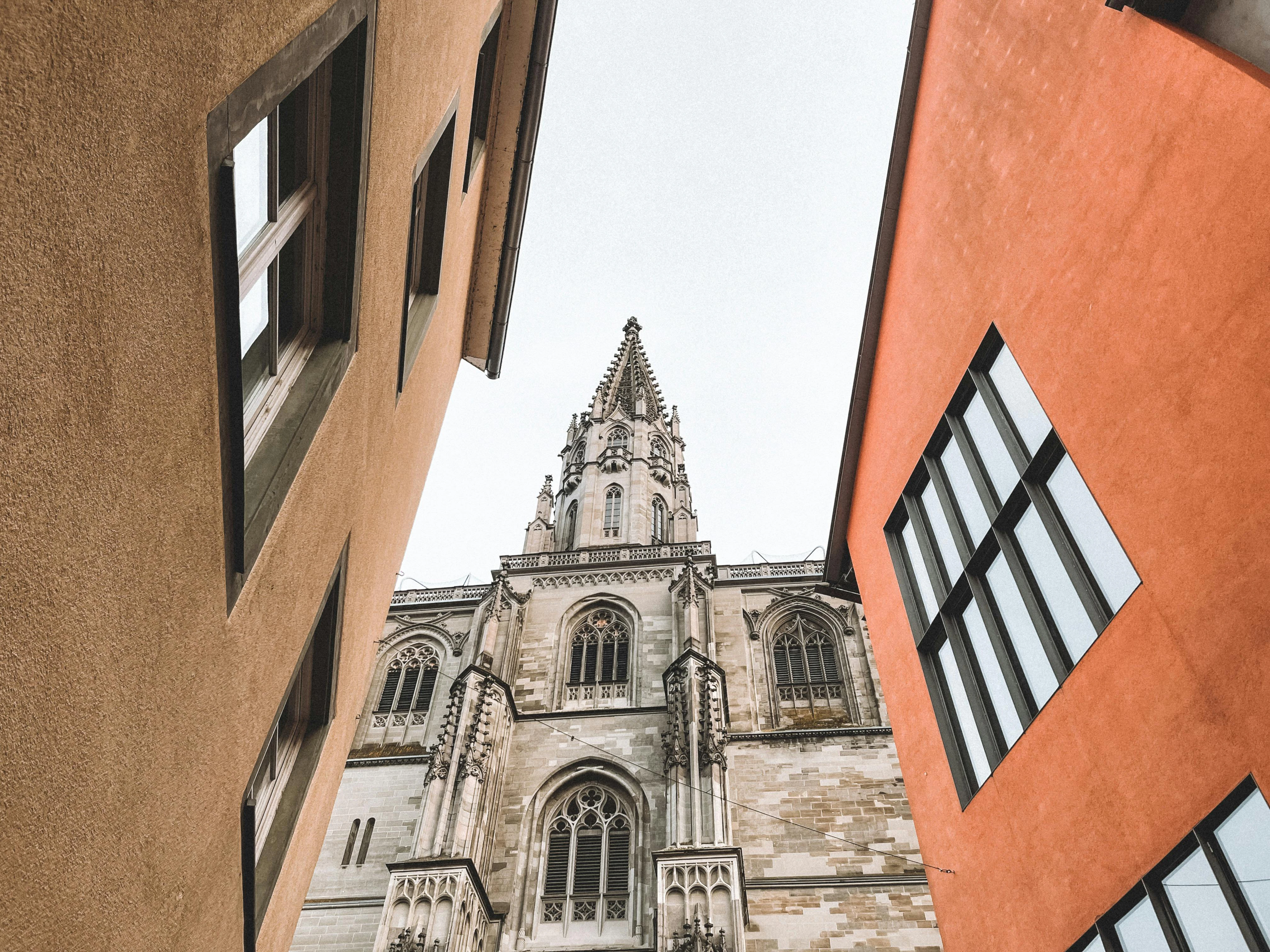 Looking up at a cathedral from between two buildings