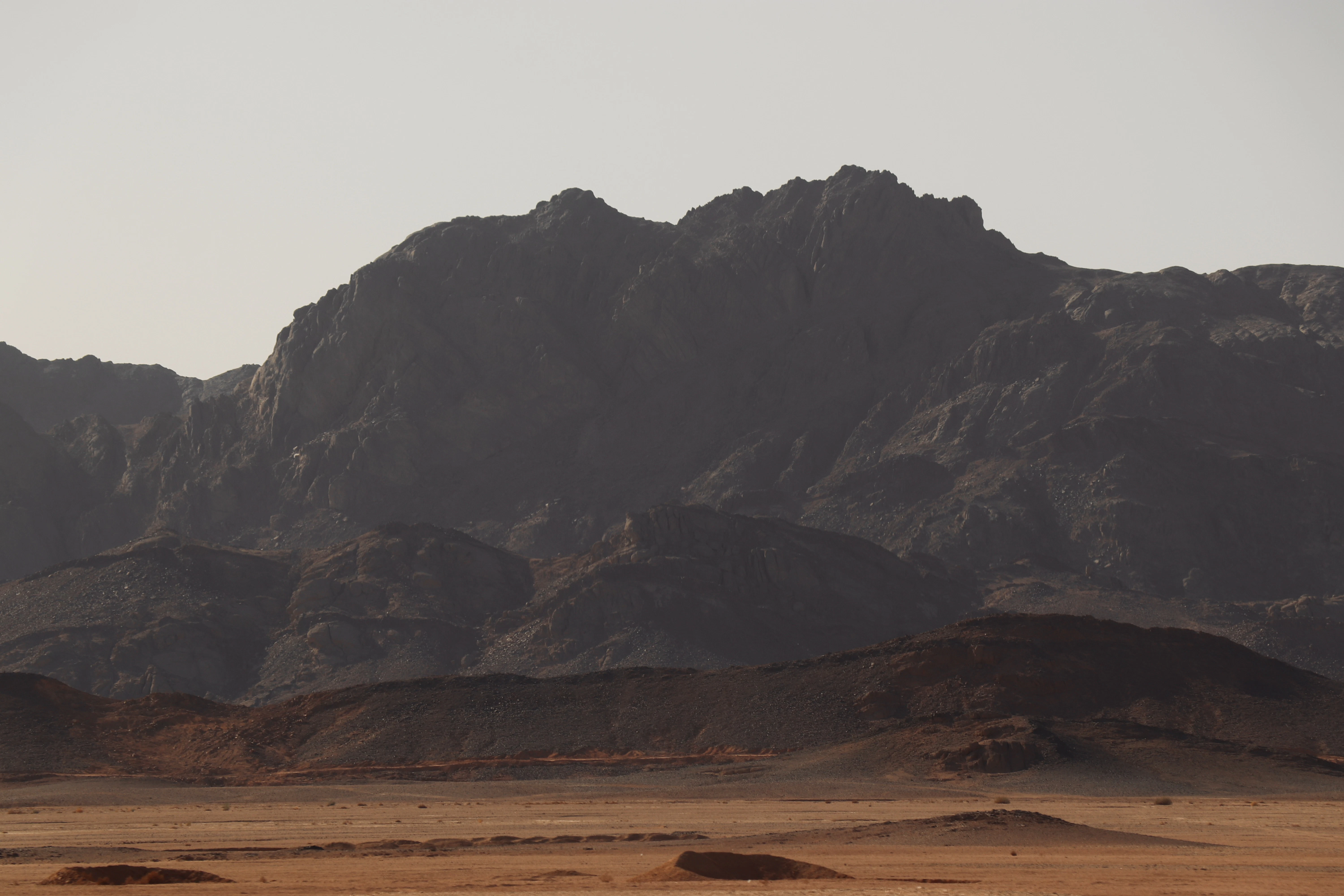 Jagged mountain range under a hazy sky