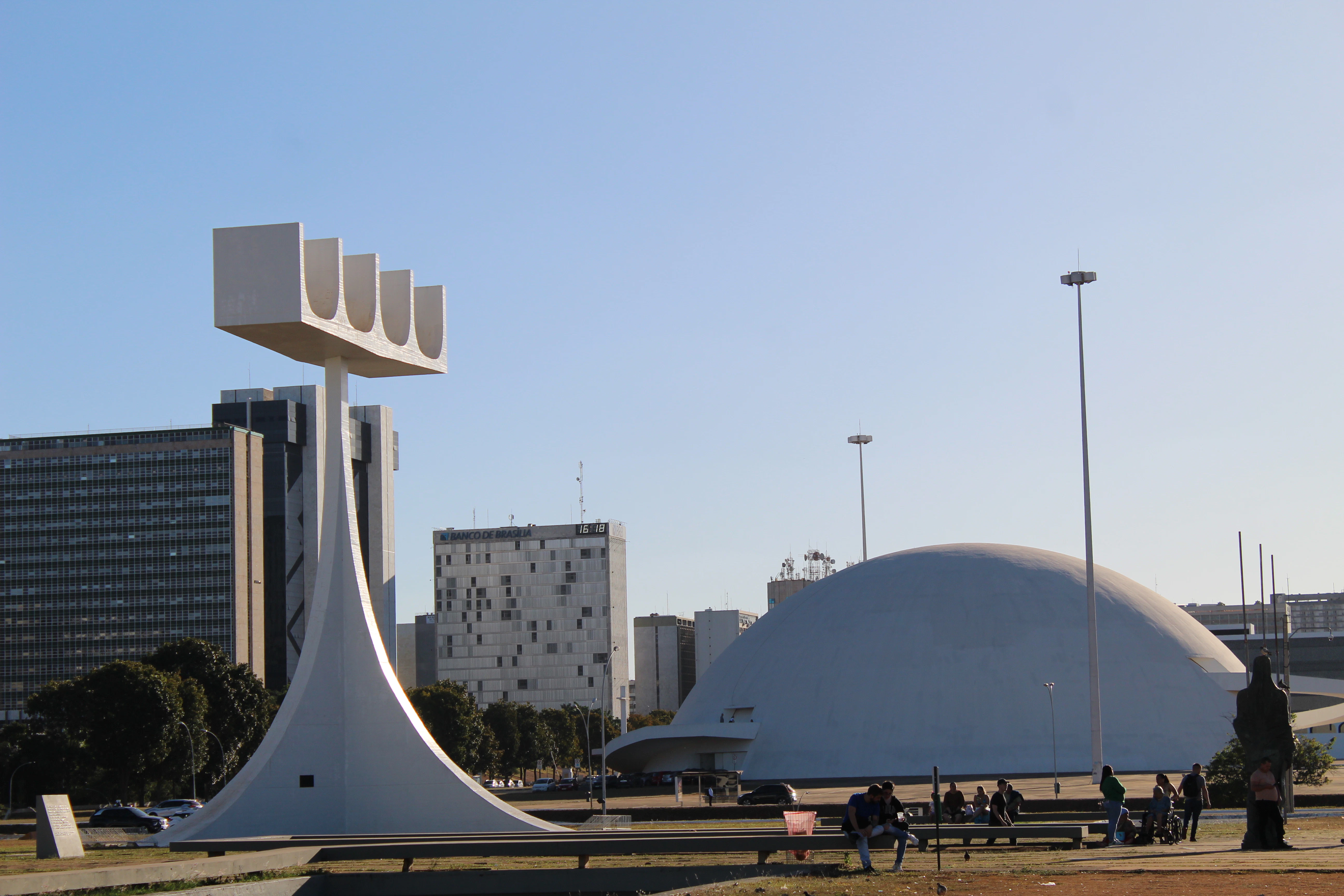 a group of people sitting on a bench in front of a building
