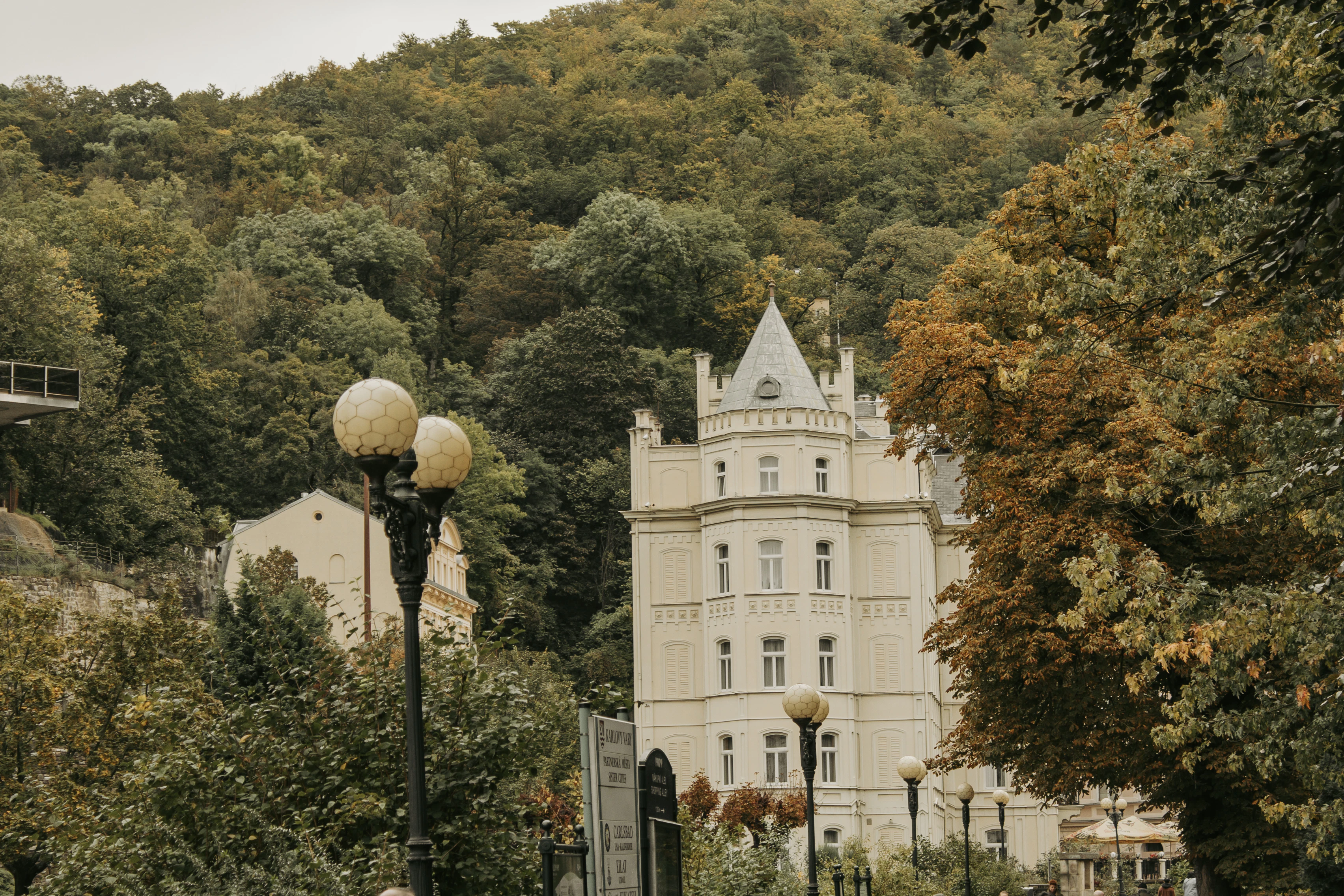 A large white building sitting on top of a lush green hillside