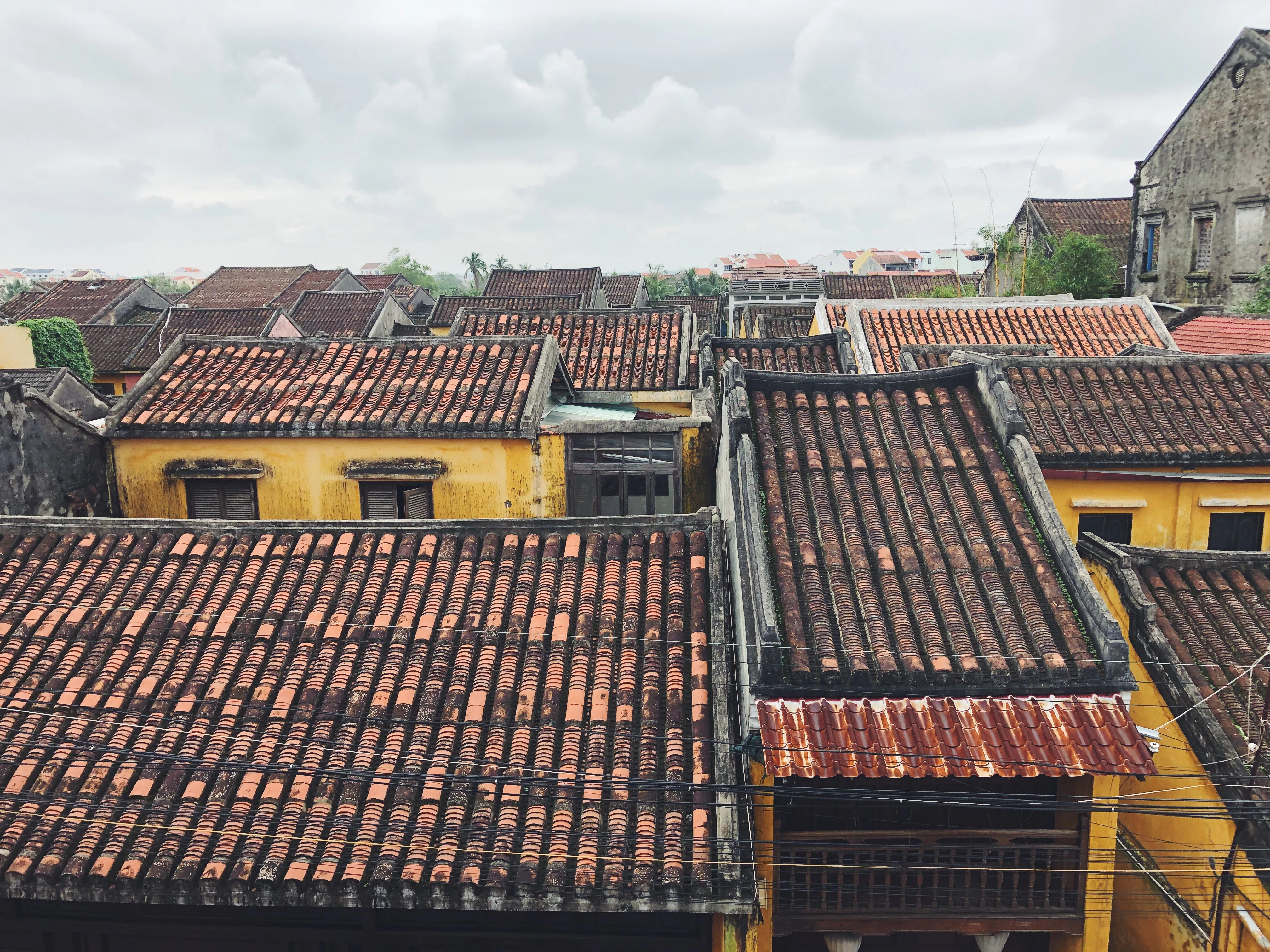 brown and black concrete houses under white clouds during daytime