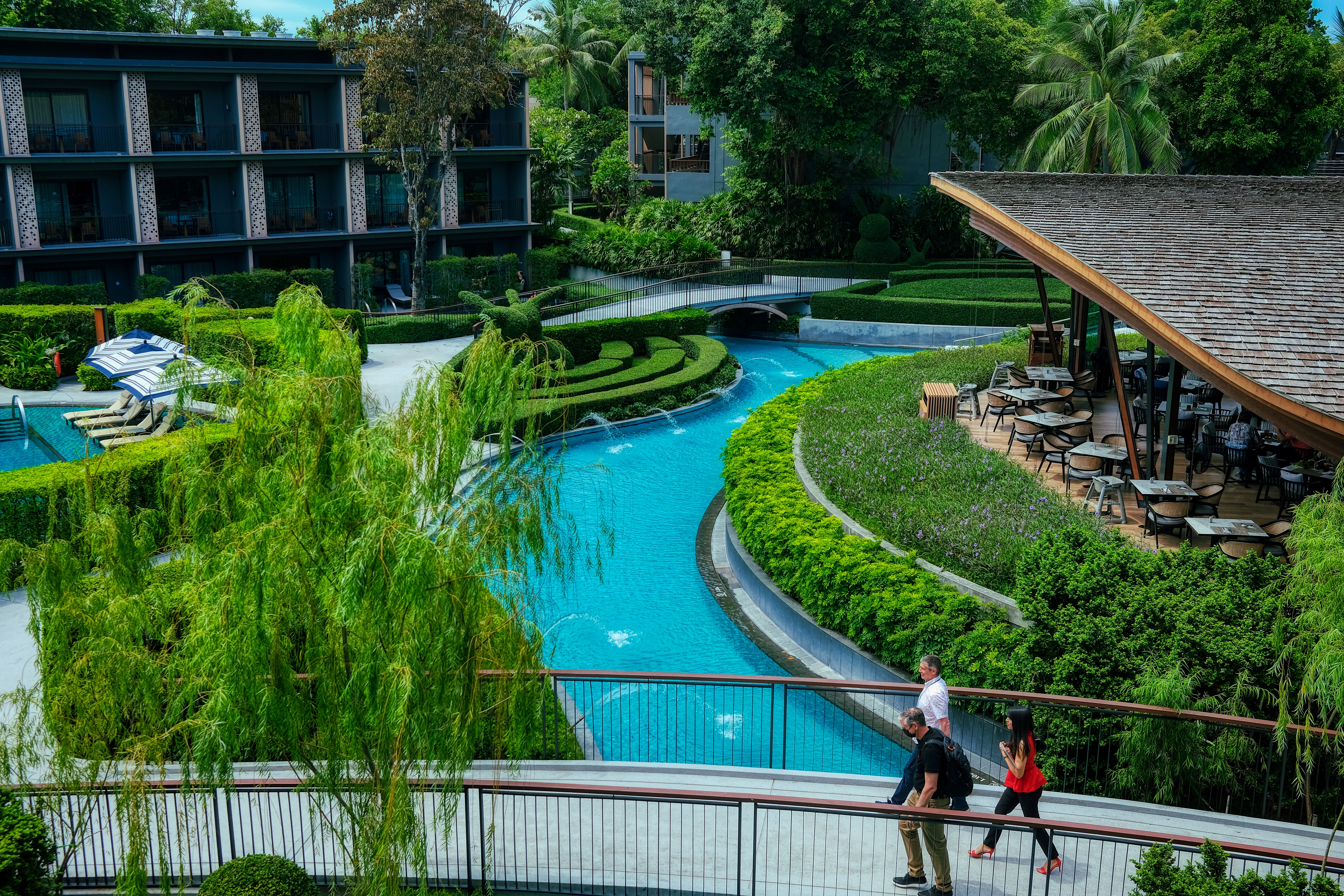 a couple of people walking across a bridge over a river