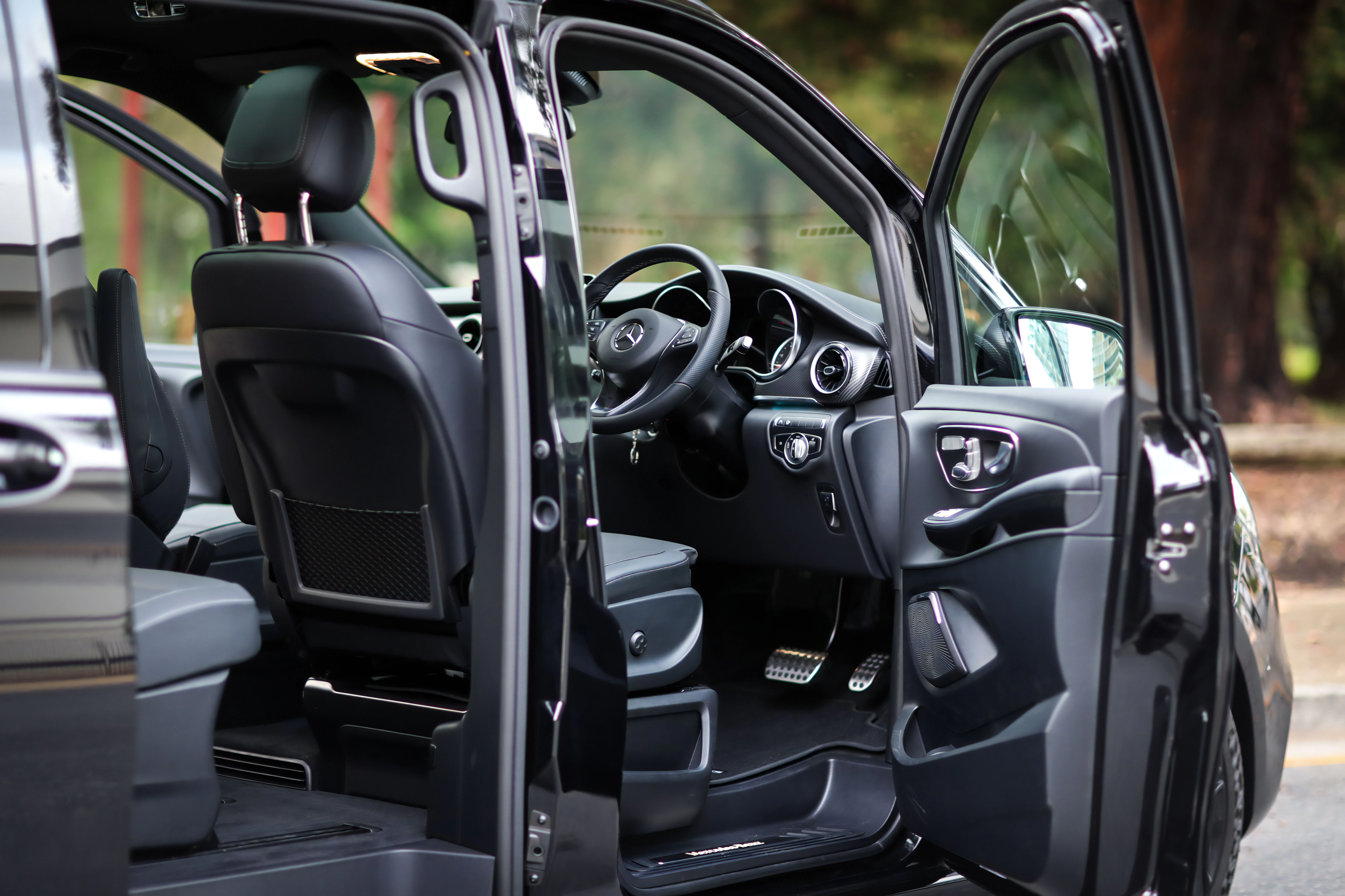 The open door shows a luxury car interior.