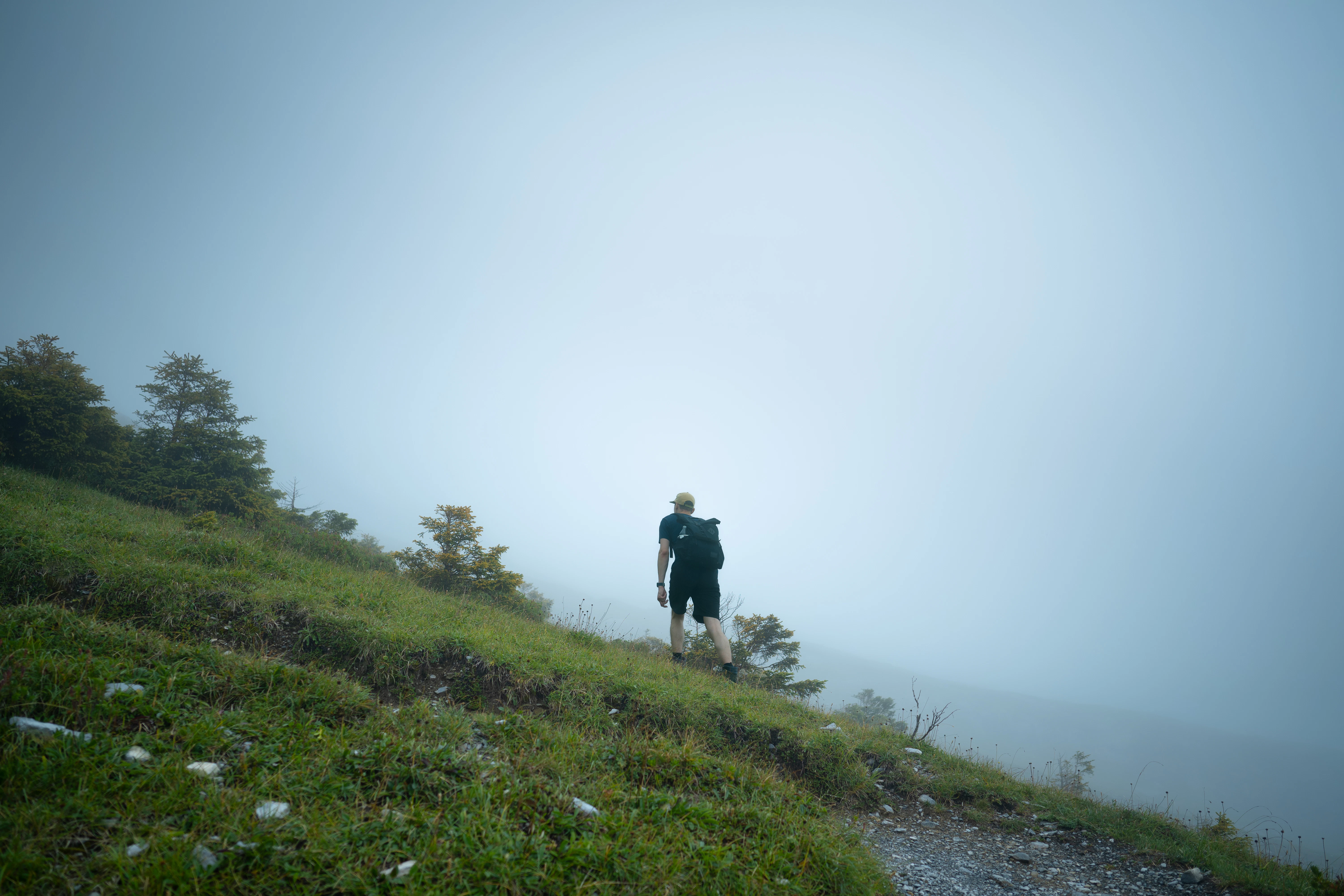 Hiker with backpack on a foggy mountain trail