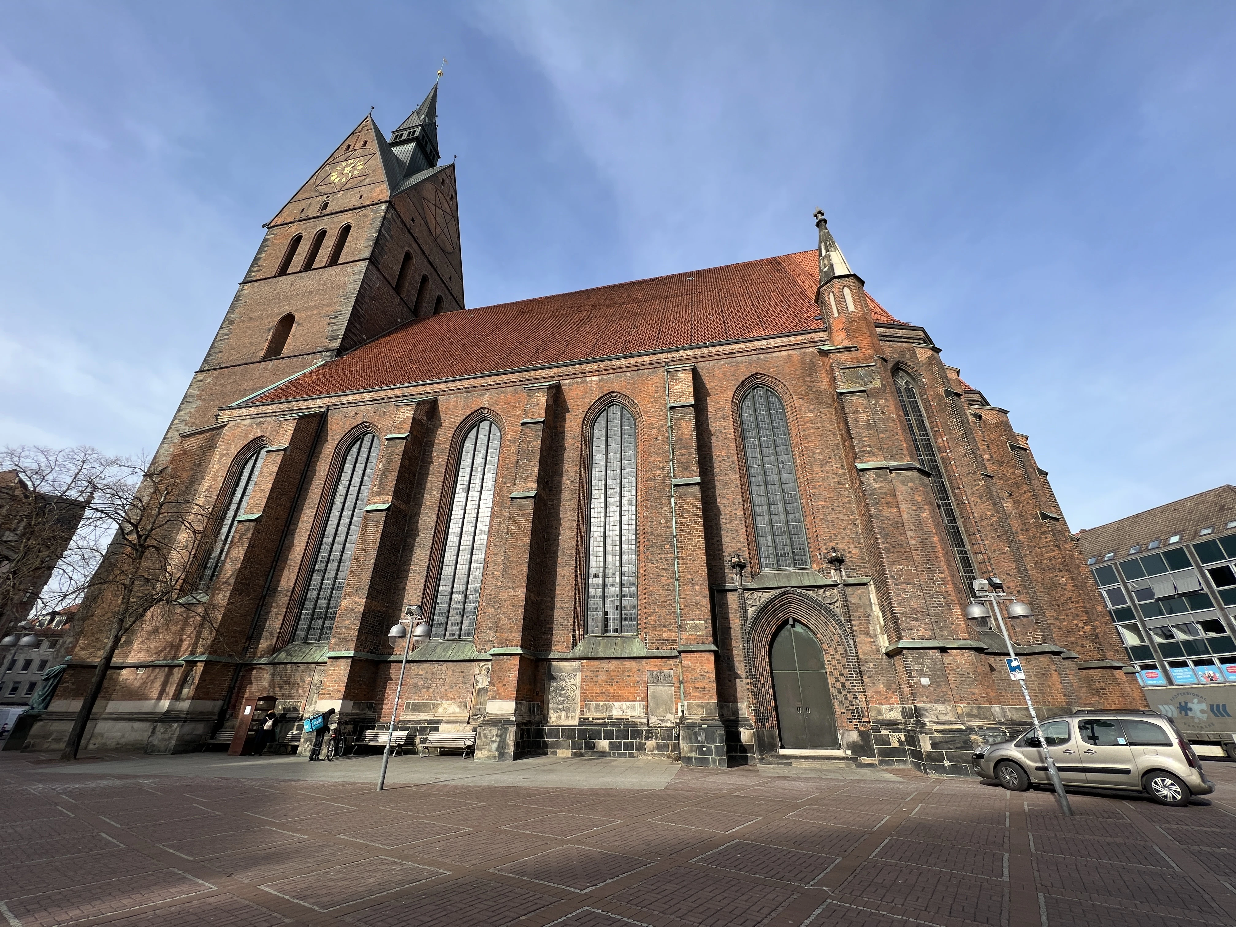 A large, brick church stands beneath a blue sky.